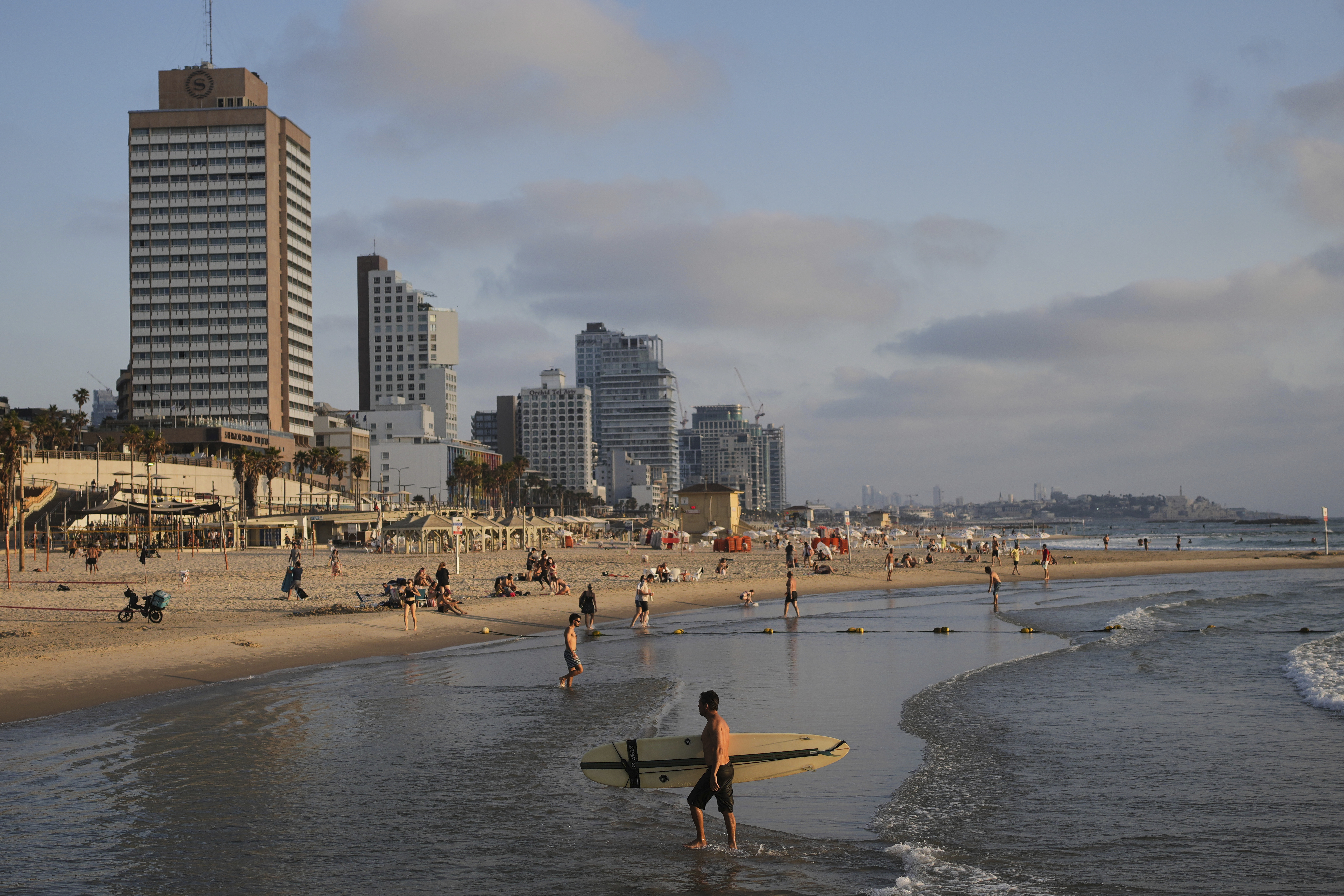 People spend the day on the Mediterranean Sea beachfront in Tel Aviv, Israel, on Saturday, June 14, 2025. (AP Photo/Ohad Zwigenberg)