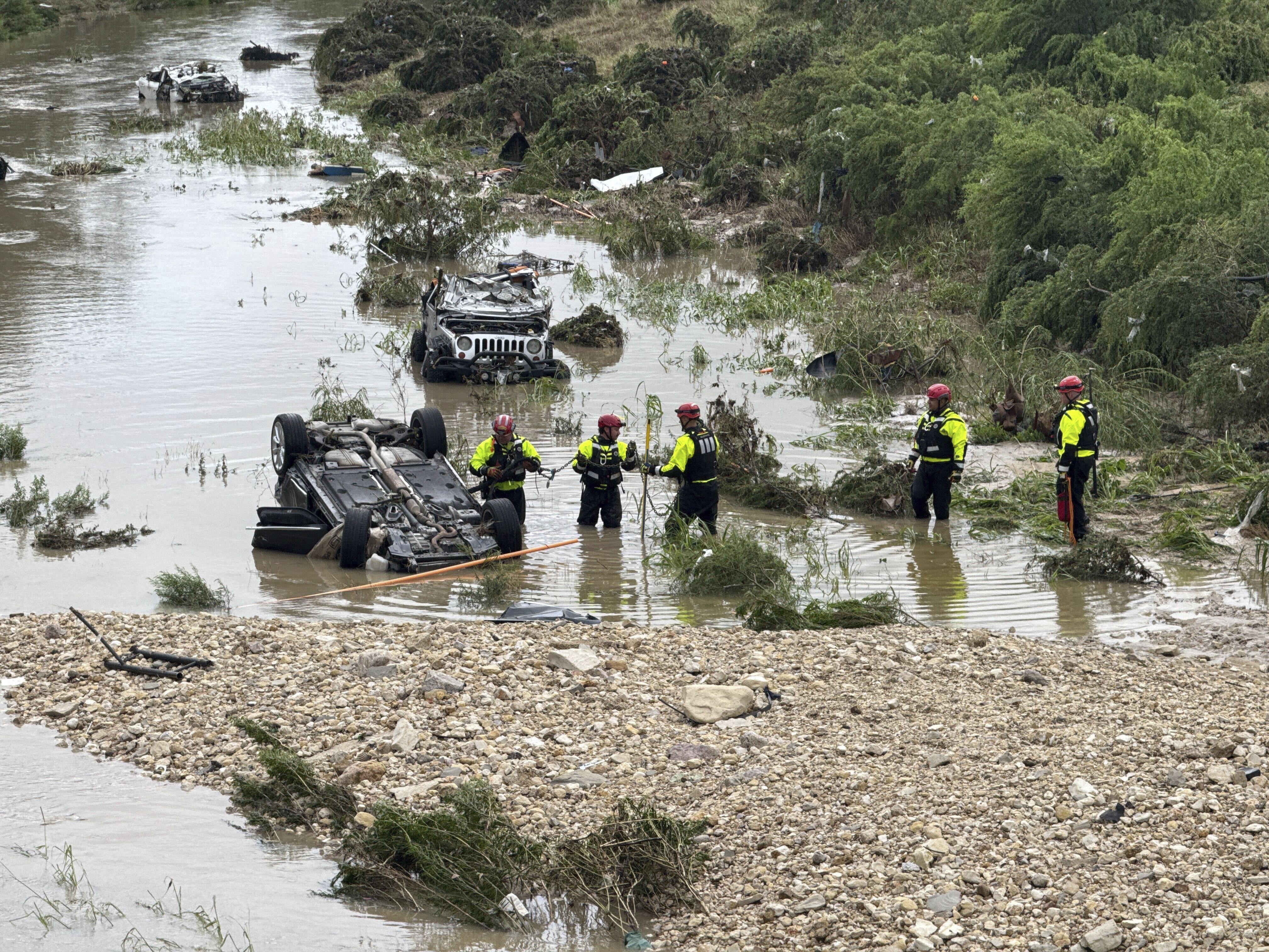 Authorities respond after vehicles were swept away by floodwaters in San Antonio, Tx., on Thursday, June 12, 2025. (AP Photo/Lekan Oyekanmi)