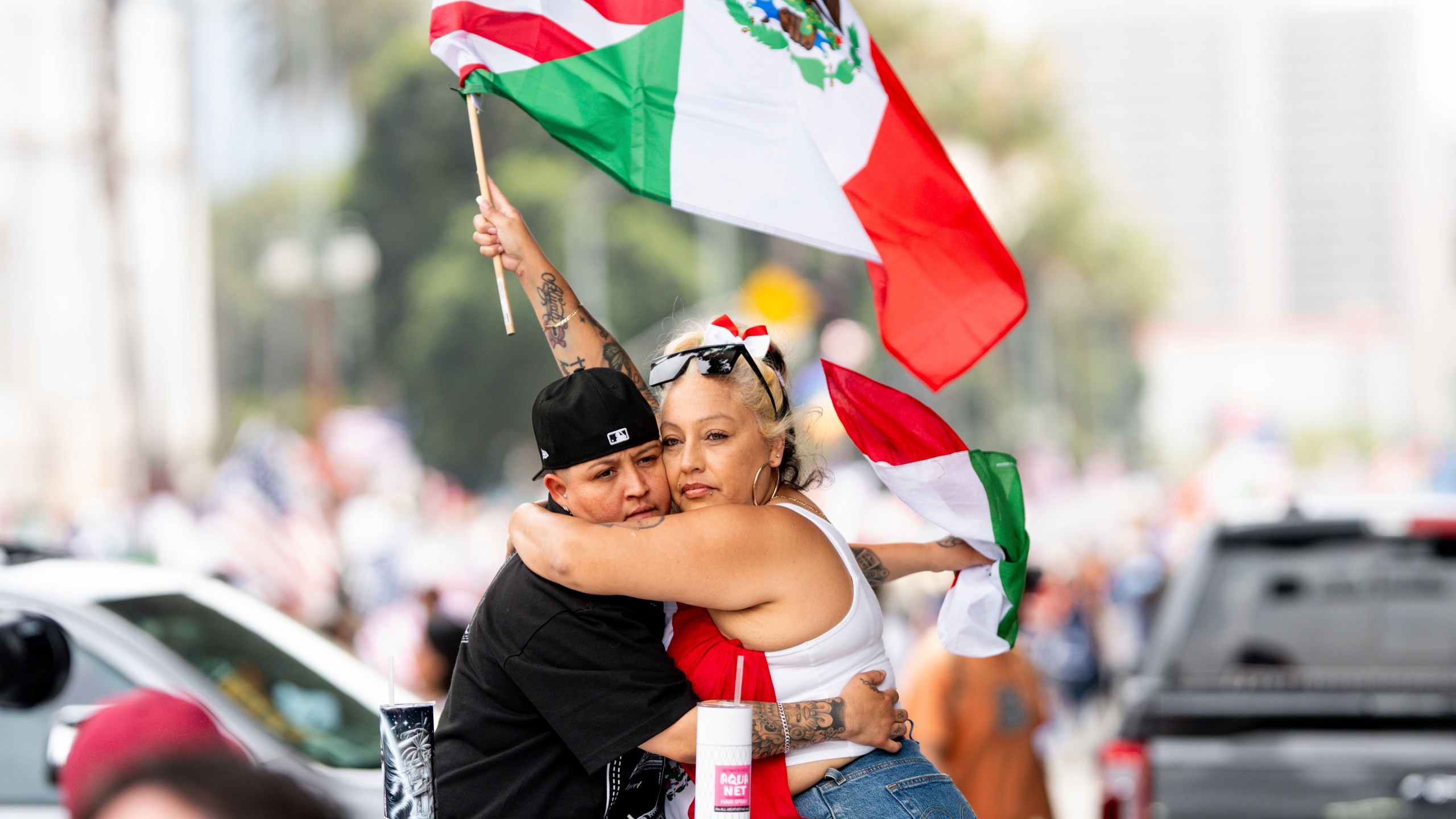 Roxy Sotu, left, and her fiancée Athena Godoy hug during a "No Kings" protest Saturday, June 14, 2025, in Los Angeles. (AP Photo/Noah Berger)