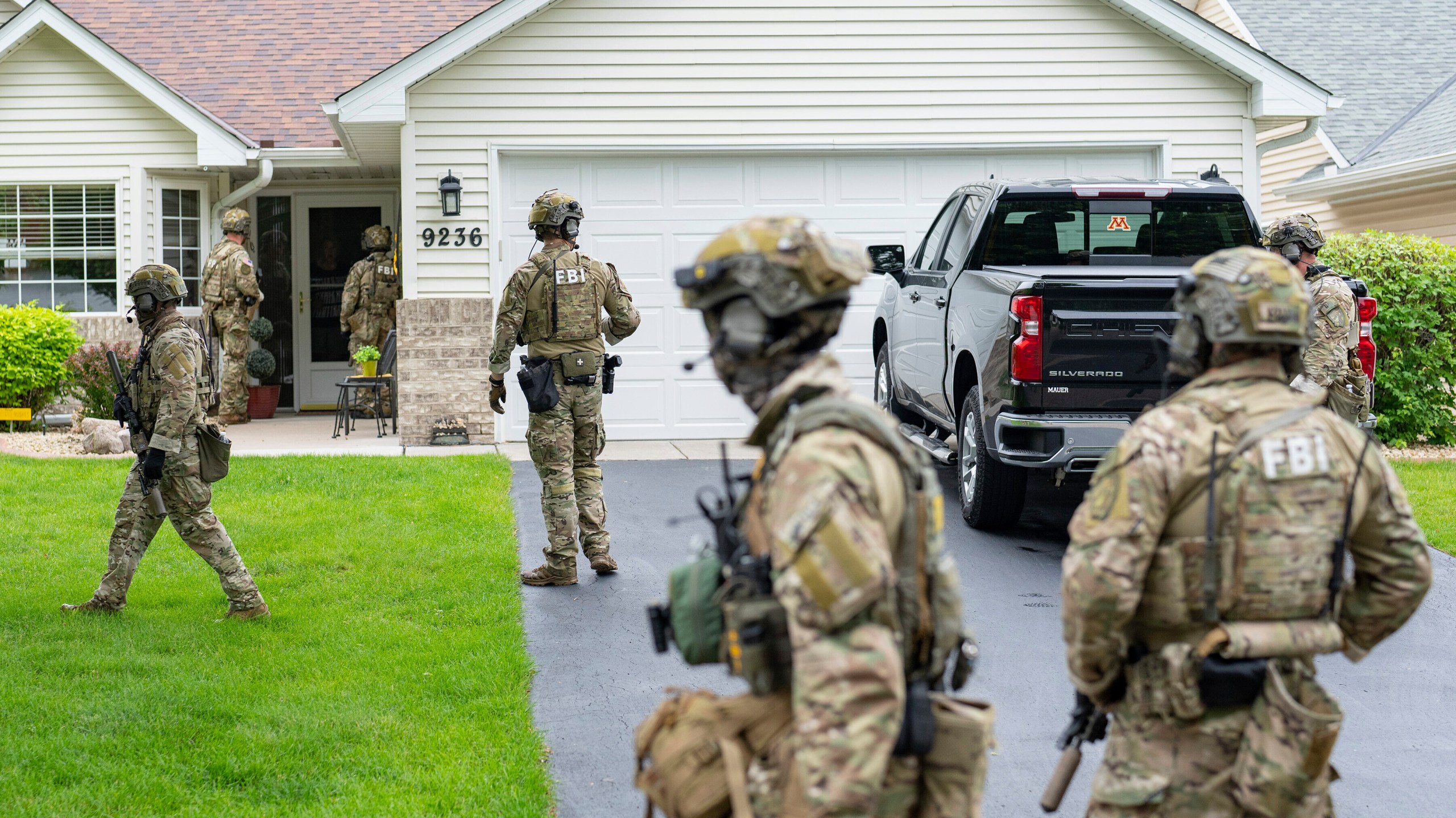 Armed FBI agents search for an active shooter, sweeping a neighborhood adjacent to the home of Minnesota DFL State Representative Melissa Hortman, in Brooklyn Park, Minn., Saturday, June 14, 2025. (Alex Kormann/Star Tribune via AP)