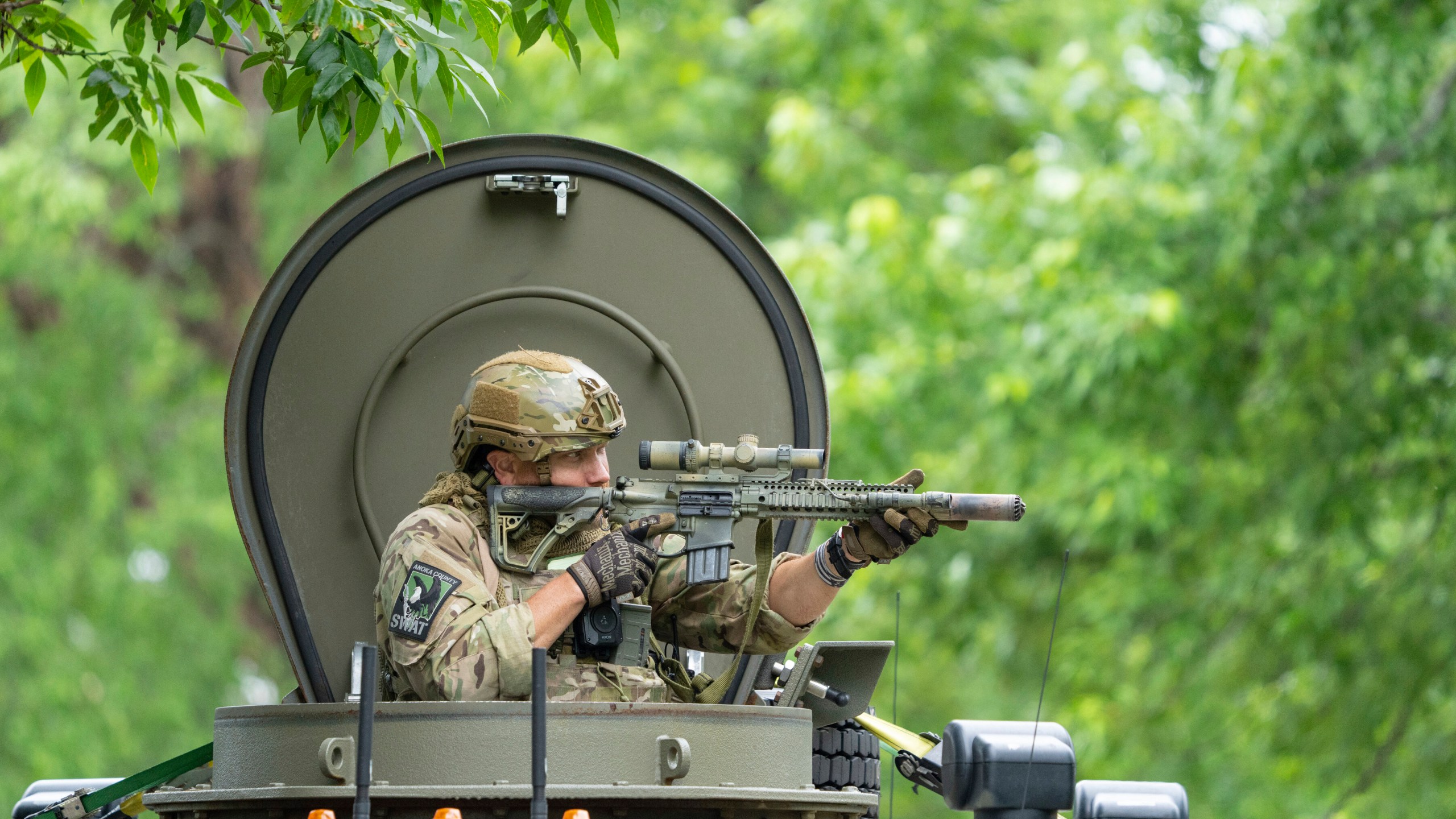 An amed FBI agent in an armored vehicle takes part in the search for an active shooter, sweeping a neighborhood adjacent to the home of Minnesota DFL State Representative Melissa Hortman, in Brooklyn Park, Minn., Saturday, June 14, 2025. (Alex Kormann/Star Tribune via AP)