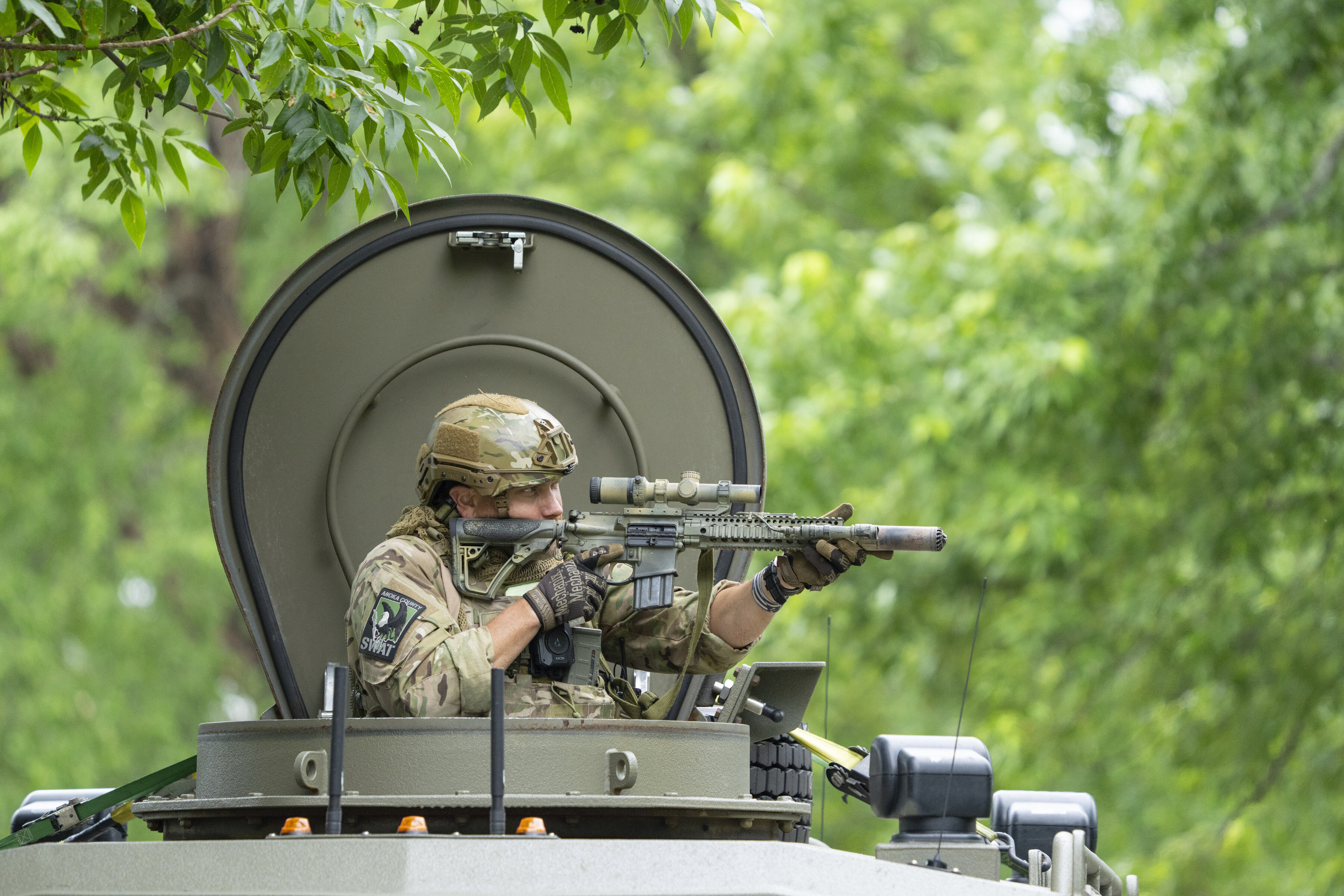 An amed FBI agent in an armored vehicle takes part in the search for an active shooter, sweeping a neighborhood adjacent to the home of Minnesota DFL State Representative Melissa Hortman, in Brooklyn Park, Minn., Saturday, June 14, 2025. (Alex Kormann/Star Tribune via AP)