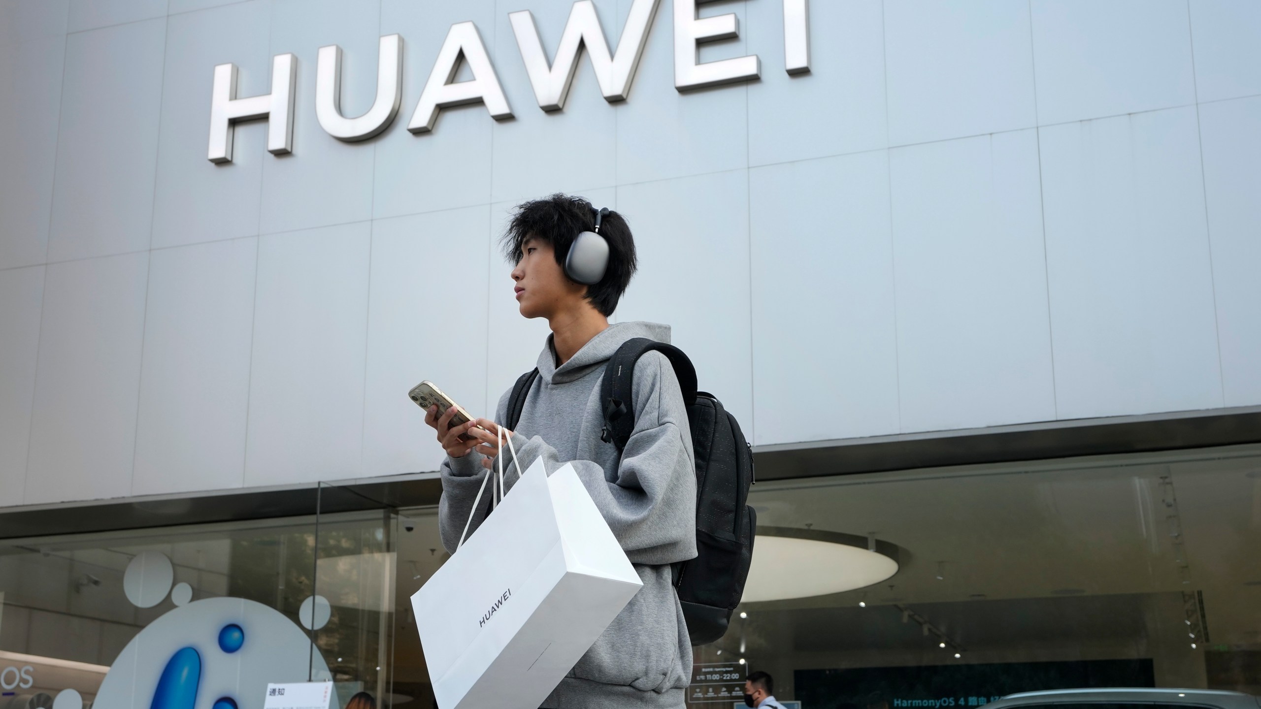 FILE - A customer carries his purchased Huawei product outside a Huawei store after he attended the Huawei new product launch conference in Beijing, on Sept. 25, 2023. (AP Photo/Andy Wong, File)