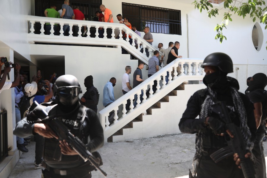 Colombians and Haitians who are accused of involvement in the 2021 assassination of Haitian President Jovenel Moise are escorted in handcuffs to their court hearing in Port-au-Prince, Haiti, Monday, May 26, 2025. (AP Photo/Odelyn Joseph)