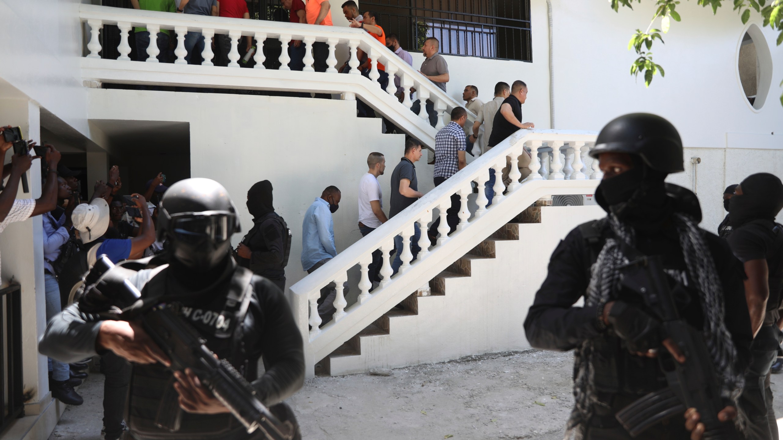 Colombians and Haitians who are accused of involvement in the 2021 assassination of Haitian President Jovenel Moise are escorted in handcuffs to their court hearing in Port-au-Prince, Haiti, Monday, May 26, 2025. (AP Photo/Odelyn Joseph)