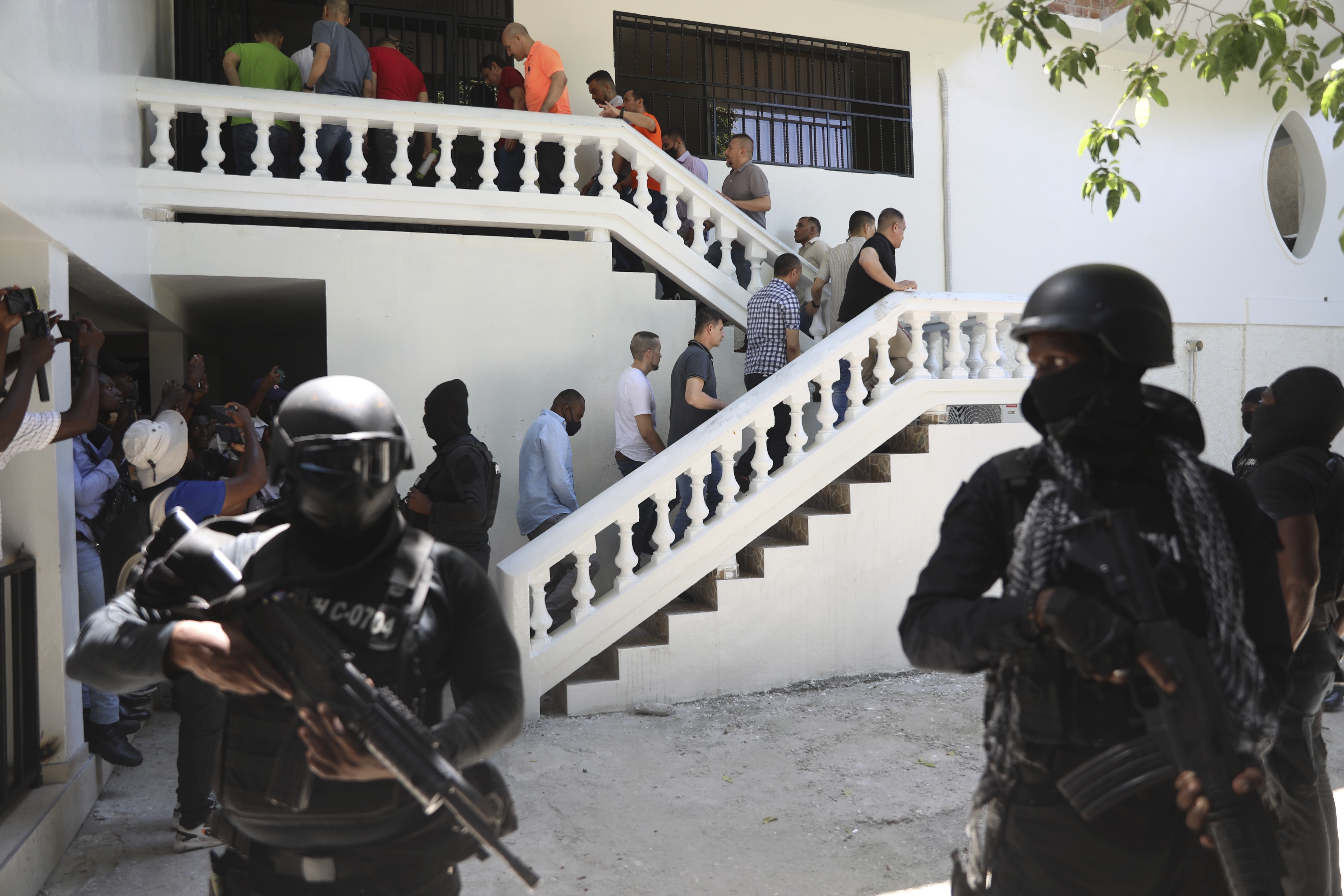 Colombians and Haitians who are accused of involvement in the 2021 assassination of Haitian President Jovenel Moise are escorted in handcuffs to their court hearing in Port-au-Prince, Haiti, Monday, May 26, 2025. (AP Photo/Odelyn Joseph)