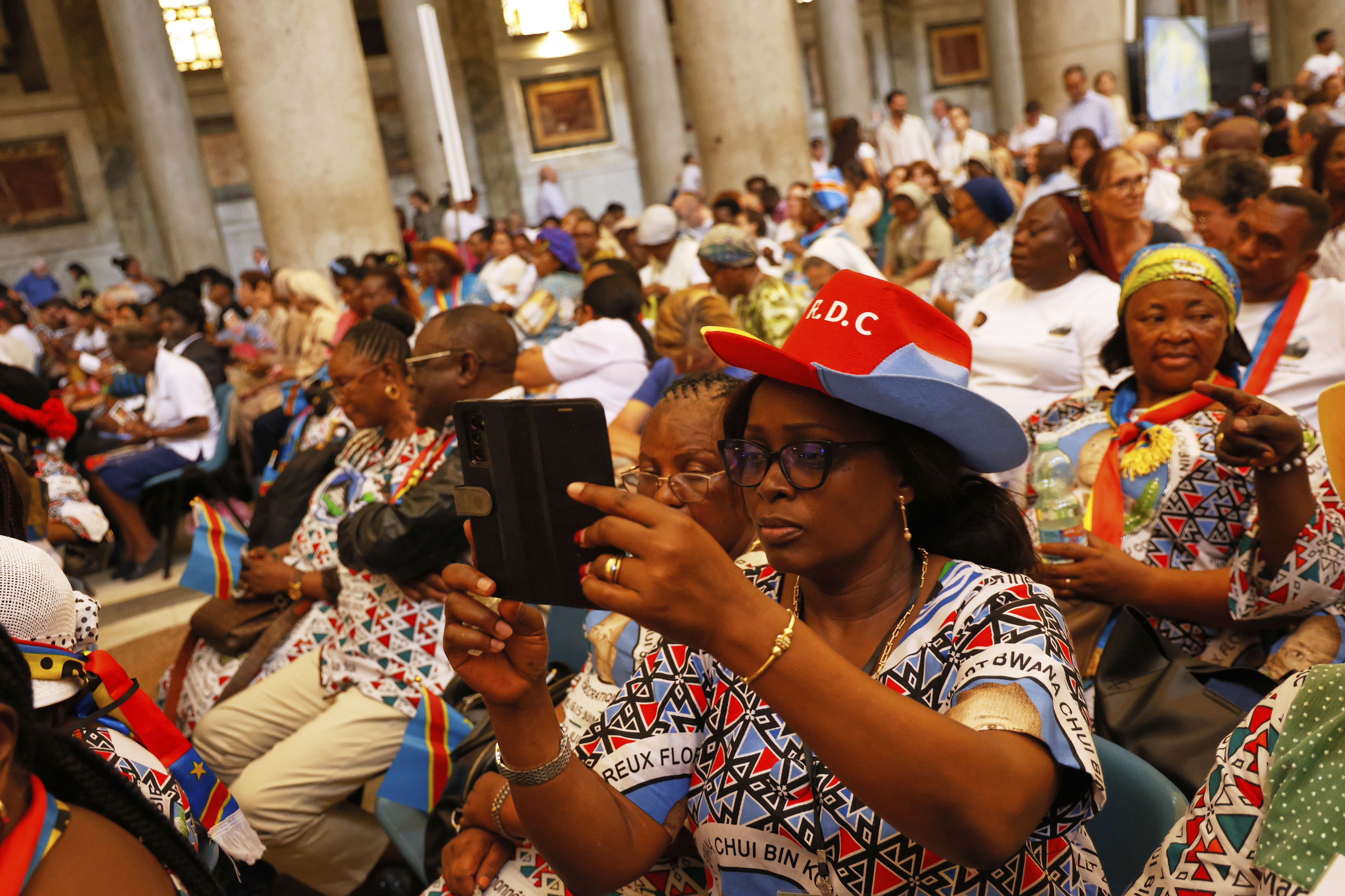 Faithful wait for the start of a beatification ceremony of Floribert Bwana Chui Bin Kositi, a Congolese man killed in 2007 for fighting corruption, in St. Paul Outside the Walls' Basilica, in Rome, Sunday, June 15, 2025. (AP Photo/Riccardo De Luca)