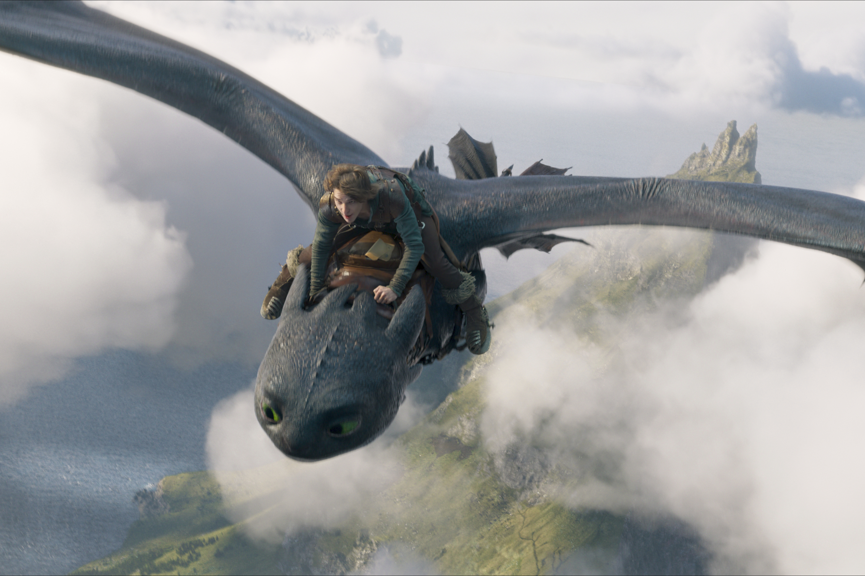This image released by Universal Pictures shows Mason Thames, as Hiccup, riding Night Fury dragon, Toothless in a scene from "How to Train Your Dragon.", (Universal Pictures via AP)