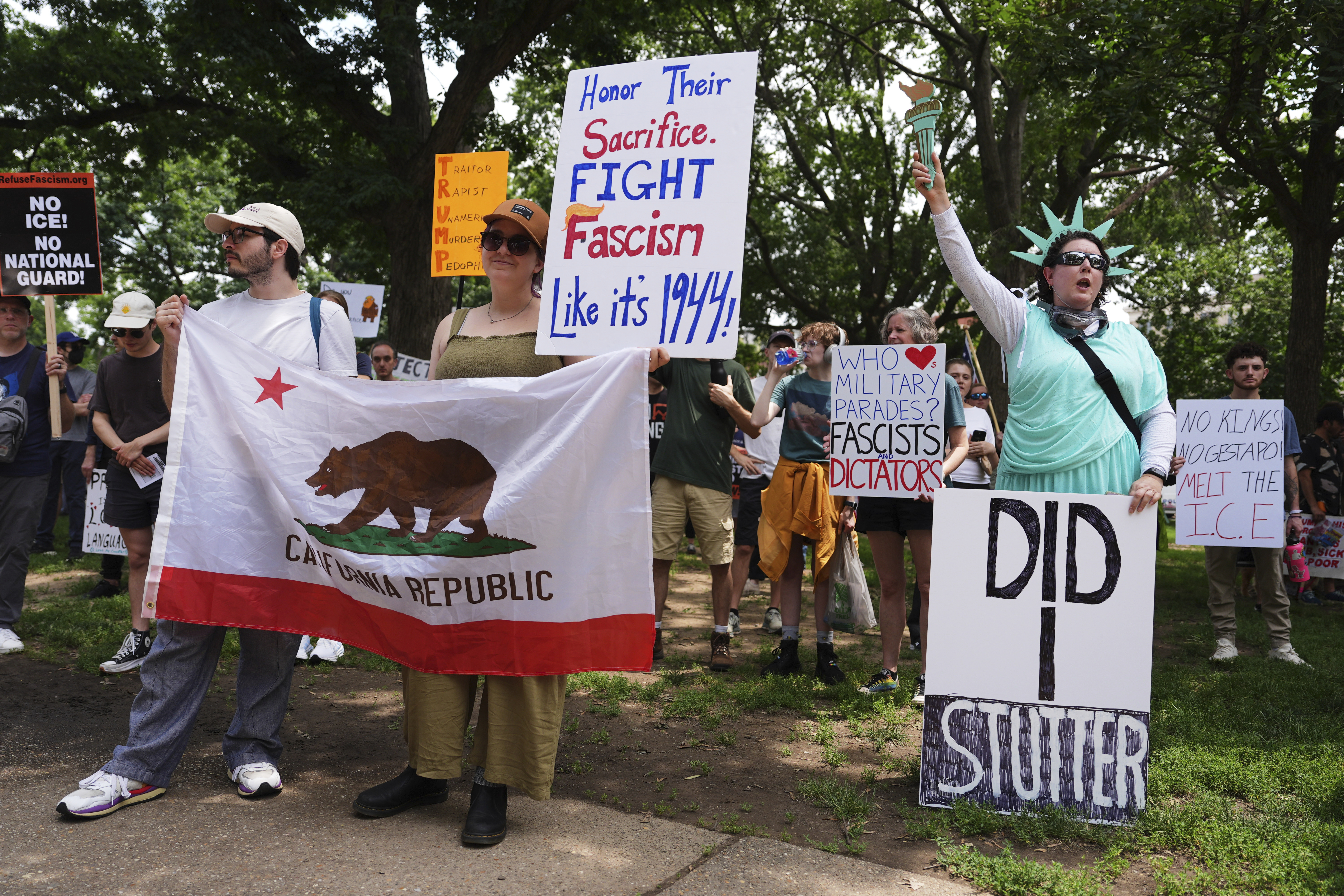 Demonstrators carry signs as they participate in a protest taking place on the day of a military parade commemorating the Army's 250th anniversary, coinciding with President Donald Trump's 79th birthday, Saturday, June 14, 2025, in Washington. (AP Photo/Evan Vucci)