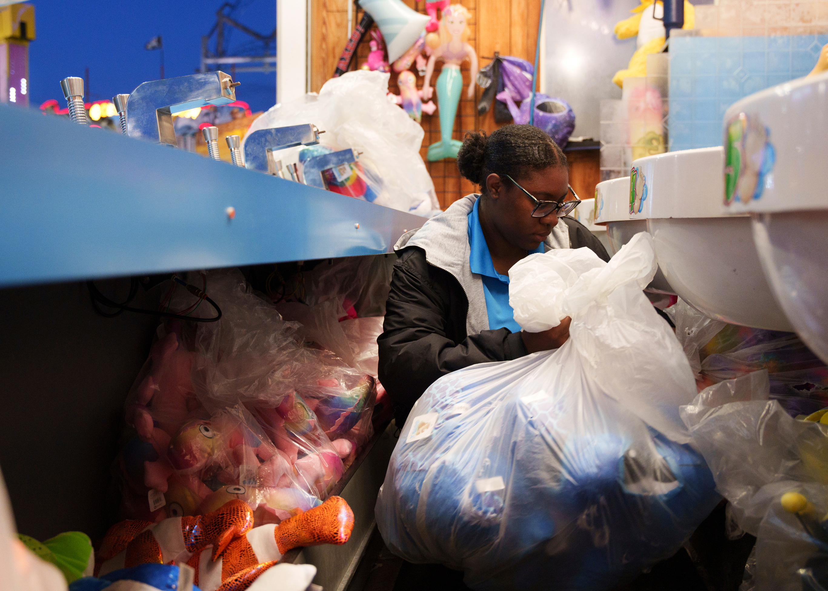 Playland's Castaway Cove booth operator Ja'Vira Blake restocks prizes at Playland's Castaway Cove amusement park, in Ocean City, N.J, on Friday, June 6, 2025. (AP Photo/Mingson Lau)