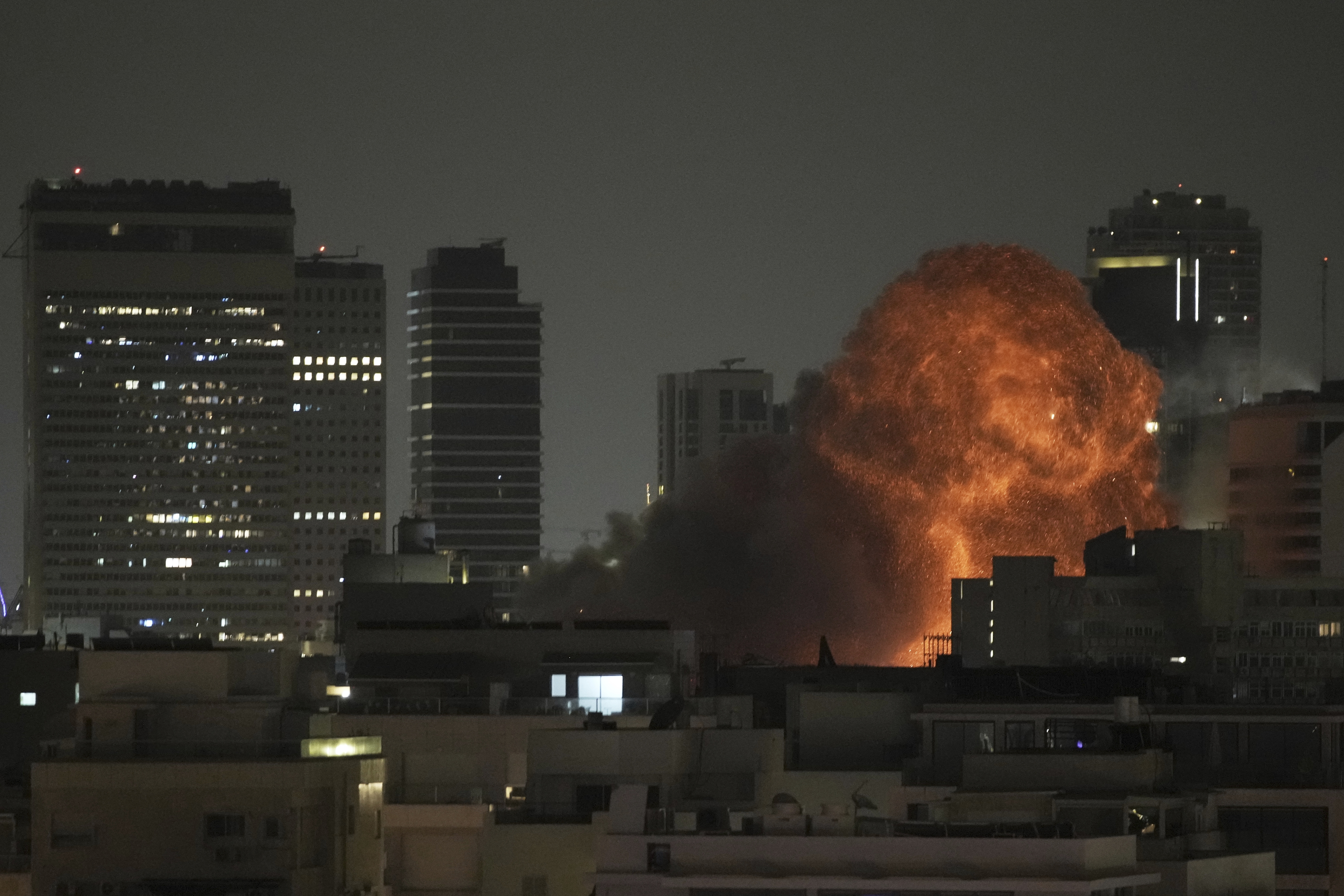 An explosion is seen during a missile attack in Tel Aviv, Israel, Sunday, June 15, 2025. (AP Photo/Leo Correa)