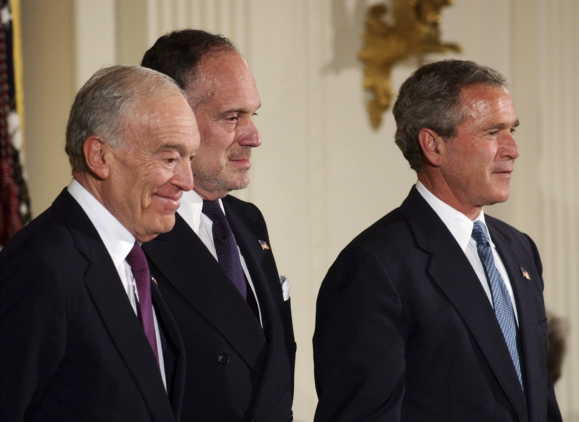 FILE- Leonard Lauder, left, and Ronald Lauder, sons of the late cosmetics mogul Estee Lauder, stand next to President Bush as they receive the Presidential Medal of Freedom on her behalf, which was awarded posthumously to her during a ceremony in the East Room of the White House in Washington Wednesday, June 23, 2004. (AP Photo/Gerald Herbert, file)