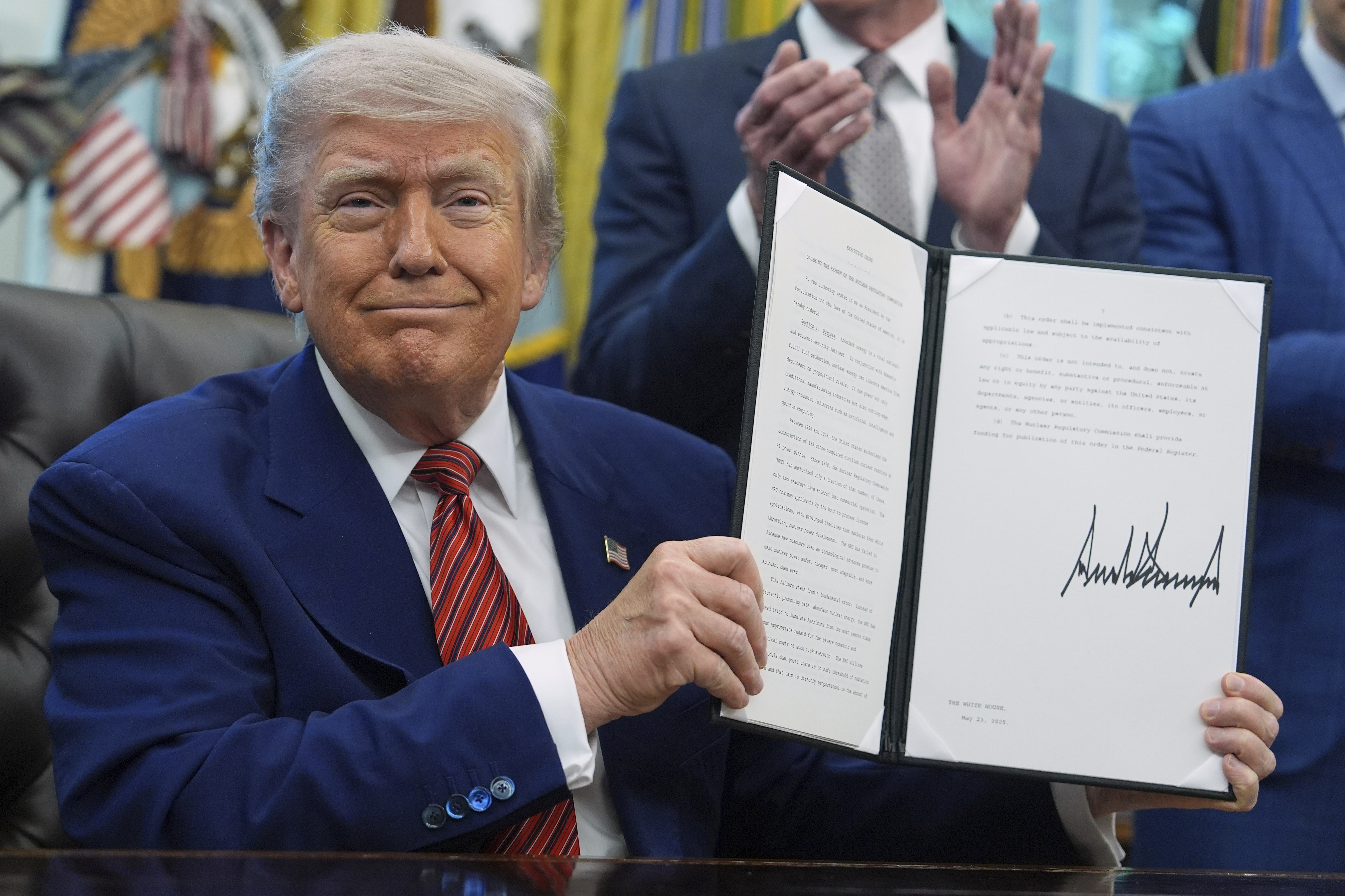 FILE - President Donald Trump holds an executive order regarding the reform of the Nuclear Regulatory Commission in the Oval Office of the White House, May 23, 2025, in Washington. (AP Photo/Evan Vucci, File)