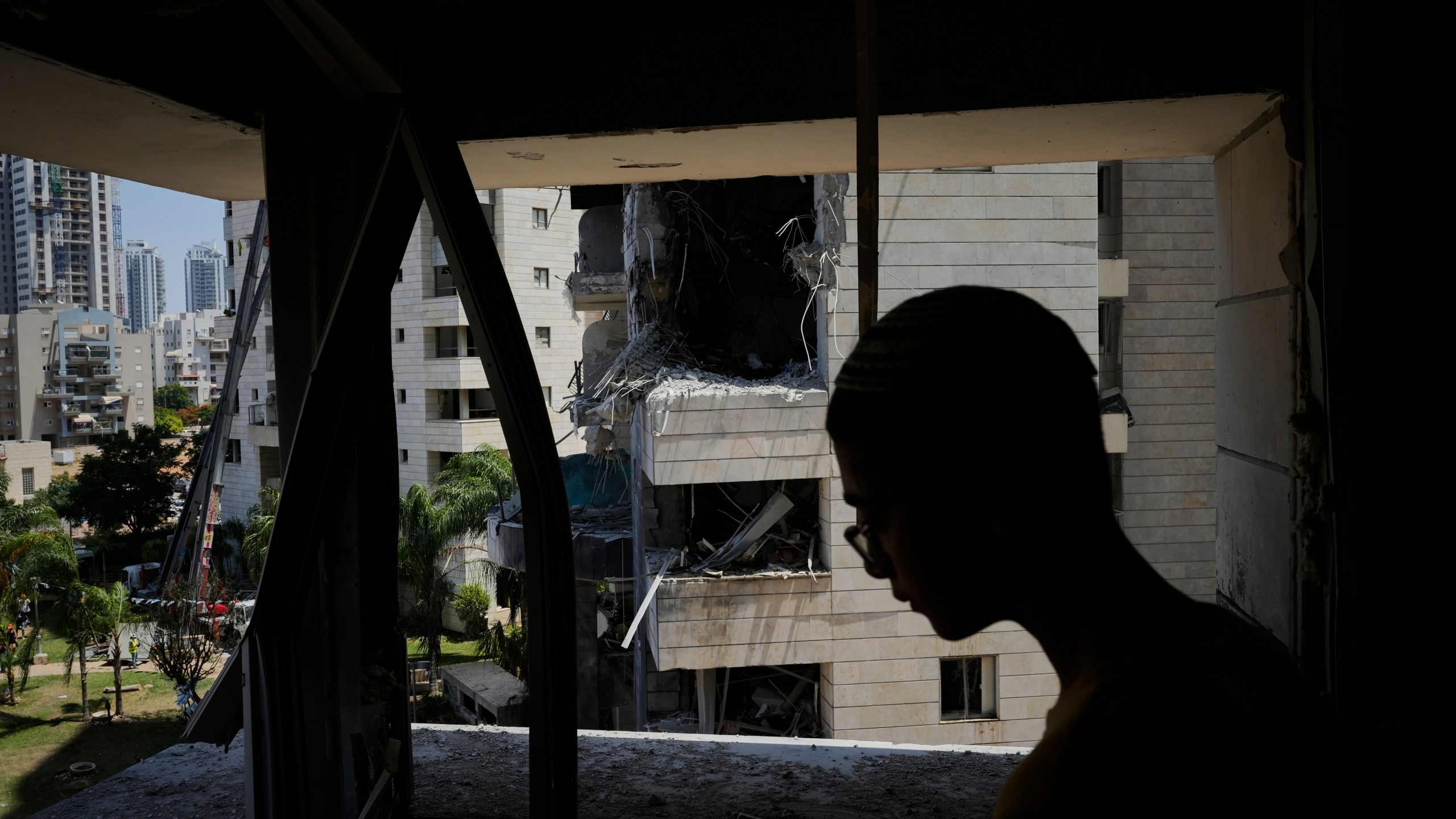 A man inspect the damage to a residential building hit by a missile launched from Iran, in Petah Tikva, Israel, Monday, June 16, 2025. (AP Photo/Baz Ratner)