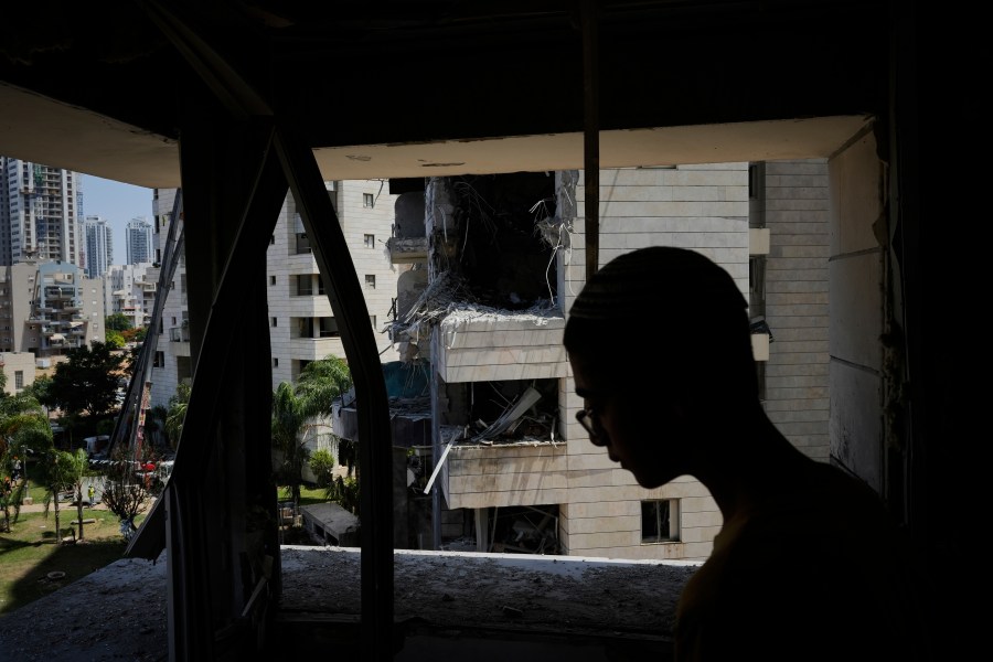A man inspect the damage to a residential building hit by a missile launched from Iran, in Petah Tikva, Israel, Monday, June 16, 2025. (AP Photo/Baz Ratner)