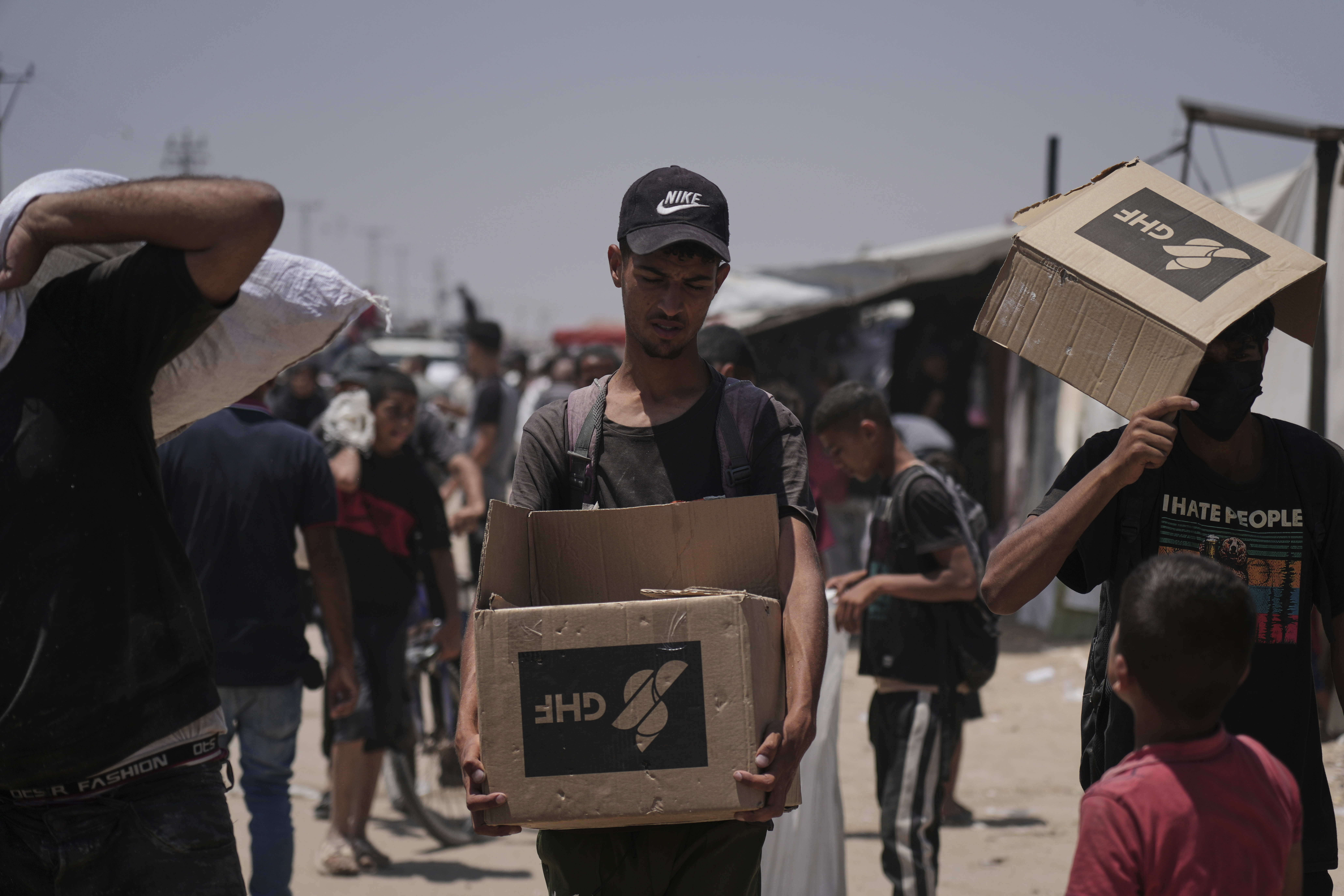 Palestinians carry bags and boxes containing food and humanitarian aid packages delivered by the Gaza Humanitarian Foundation, a U.S.-backed organization, in Rafah, southern Gaza Strip, Monday, June 16, 2025. (AP Photo/Abdel Kareem Hana)