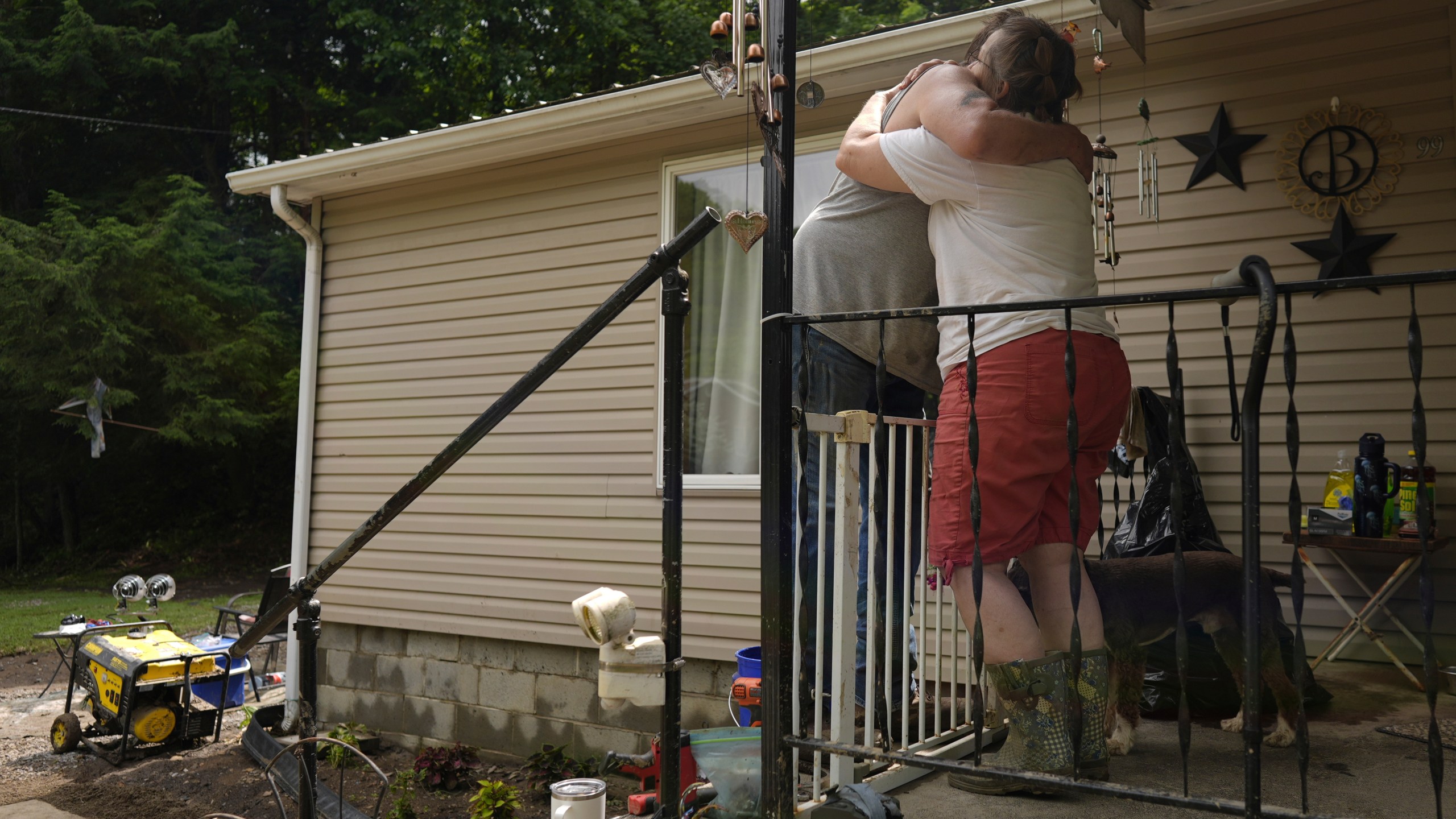 Norma and John Black hug outside their flood-damaged home, Monday, June 16, 2025, in Valley Grove, W.Va. (AP Photo/Carolyn Kaster)