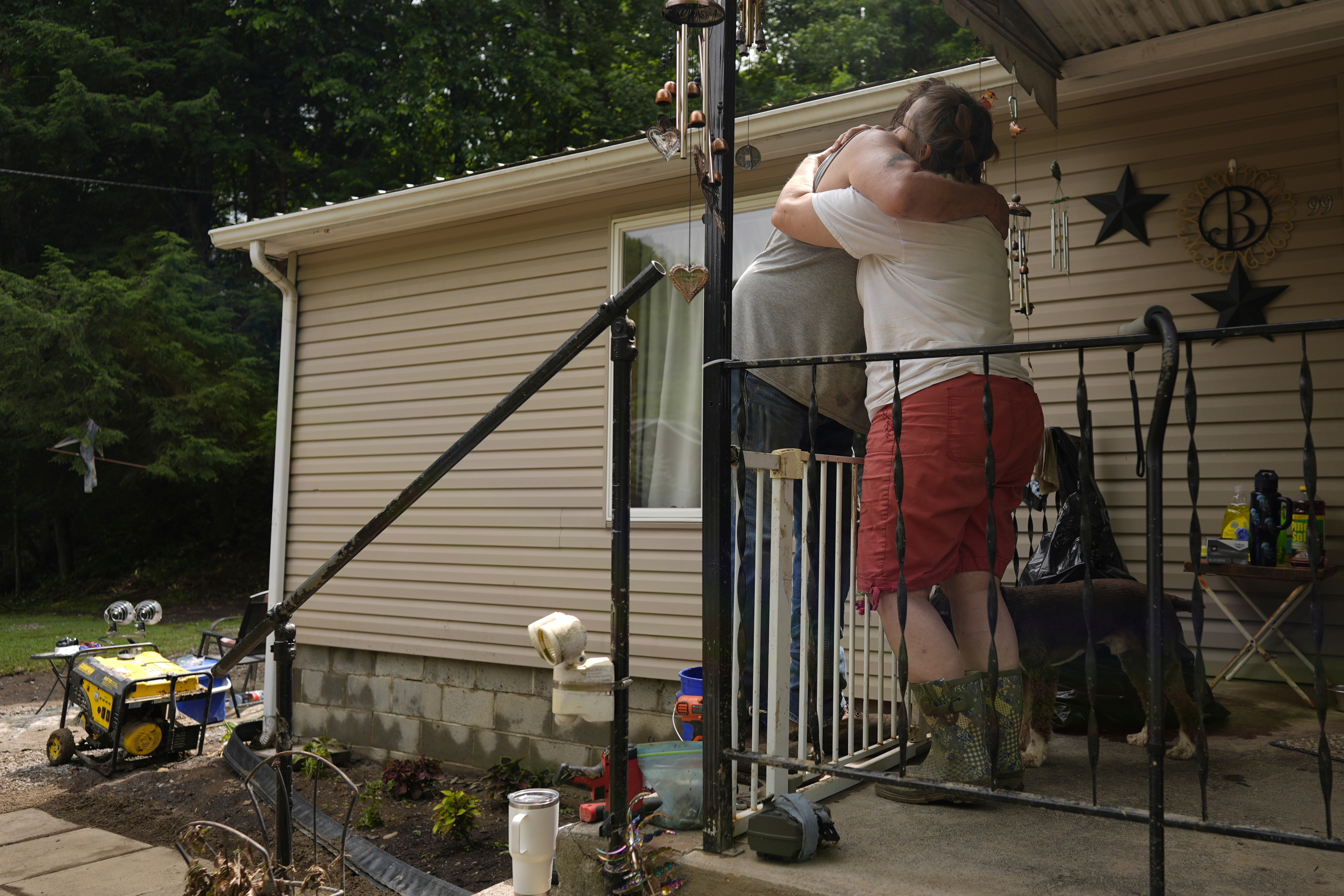 Norma and John Black hug outside their flood-damaged home, Monday, June 16, 2025, in Valley Grove, W.Va. (AP Photo/Carolyn Kaster)