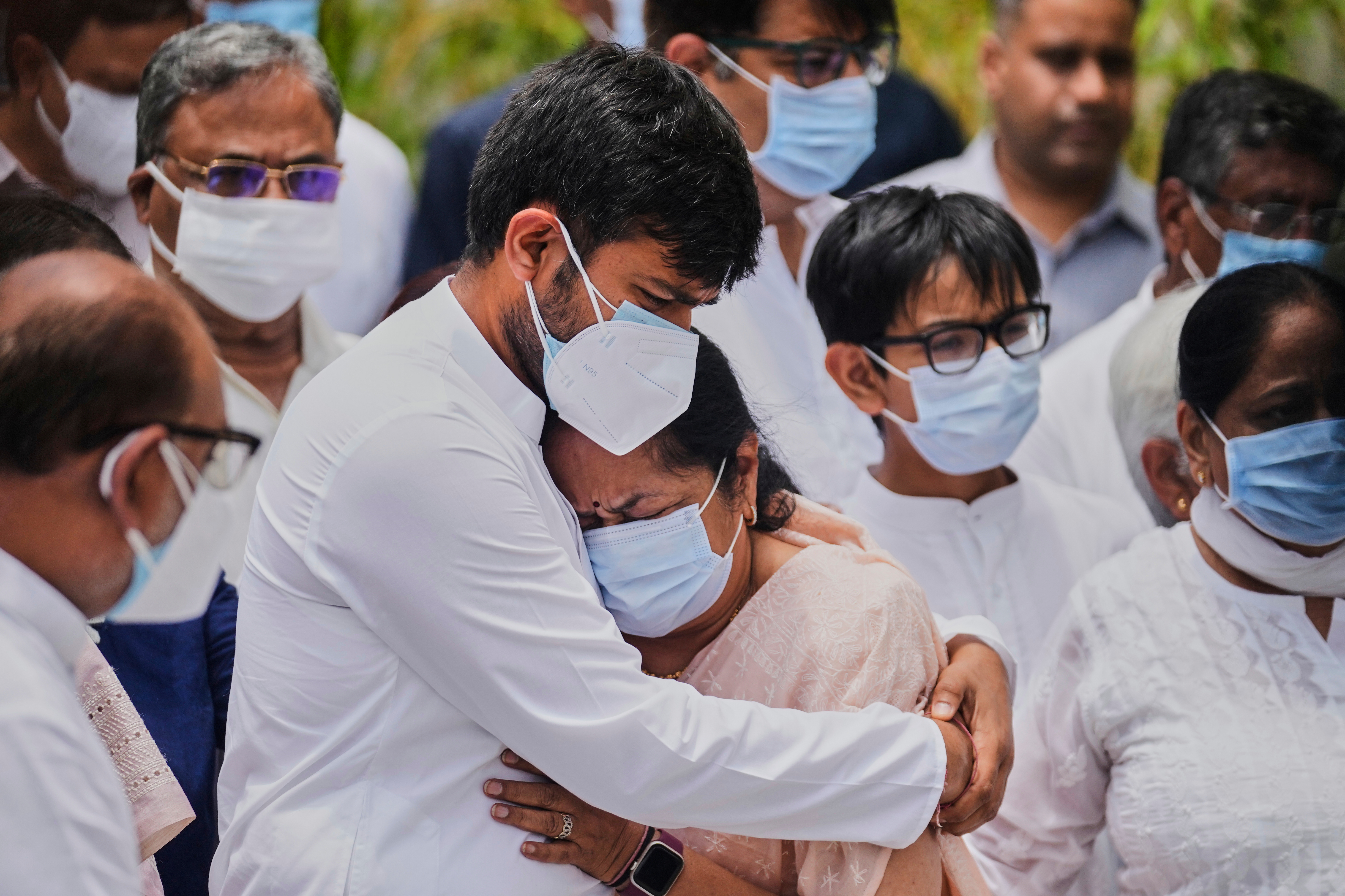 Anjali Rupani, the wife of former Chief Minister of Gujarat Vijay Rupani, who died in the Air India plane crash, is comforted by her son during a wreath-laying ceremony outside the mortuary of a hospital in Ahmedabad, India, Monday, June 16, 2025. (AP Photo/Rafiq Maqbool)