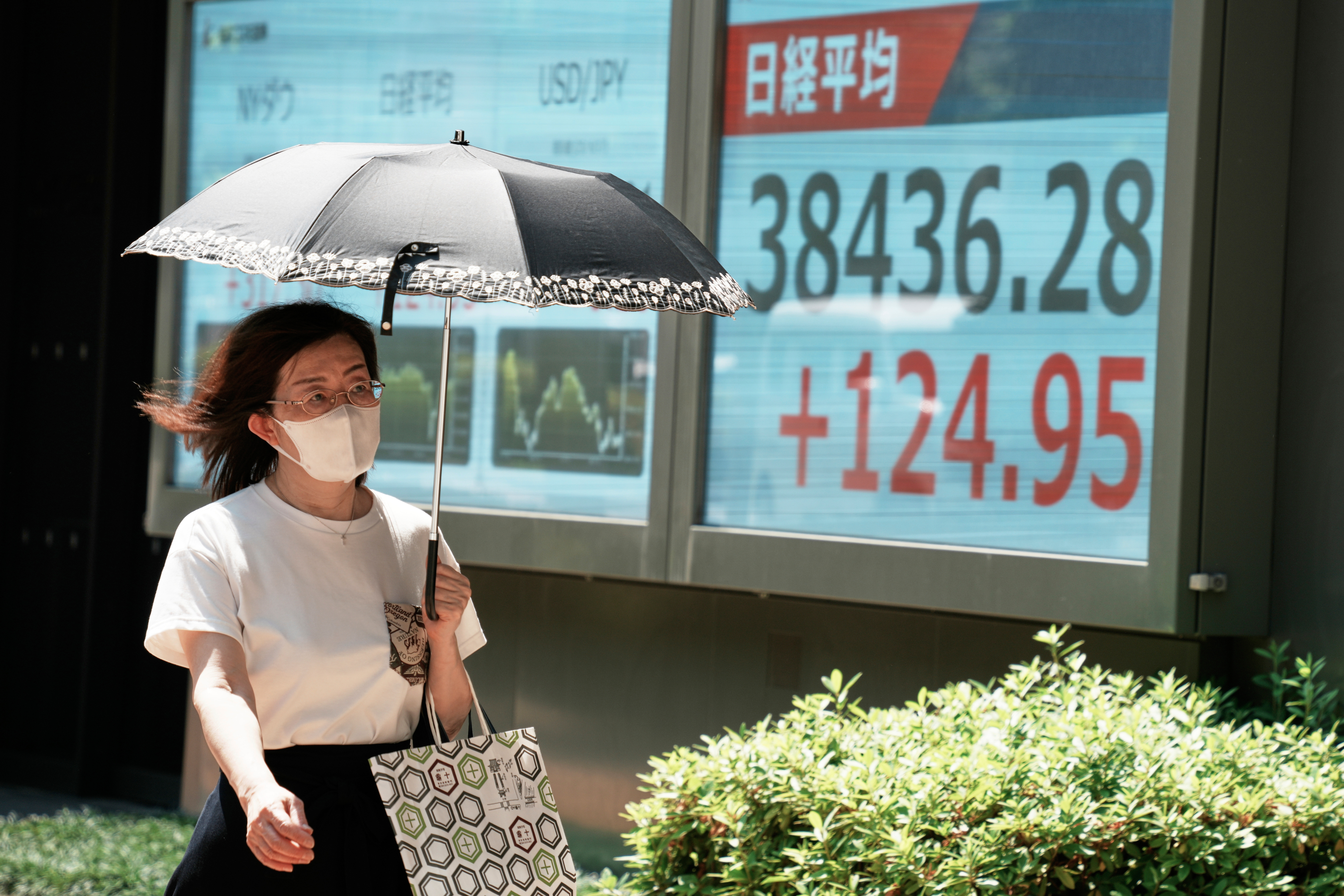 A person walks in front of an electronic stock board showing Japan's Nikkei index at a securities firm Tuesday, June 17, 2025, in Tokyo. (AP Photo/Eugene Hoshiko)