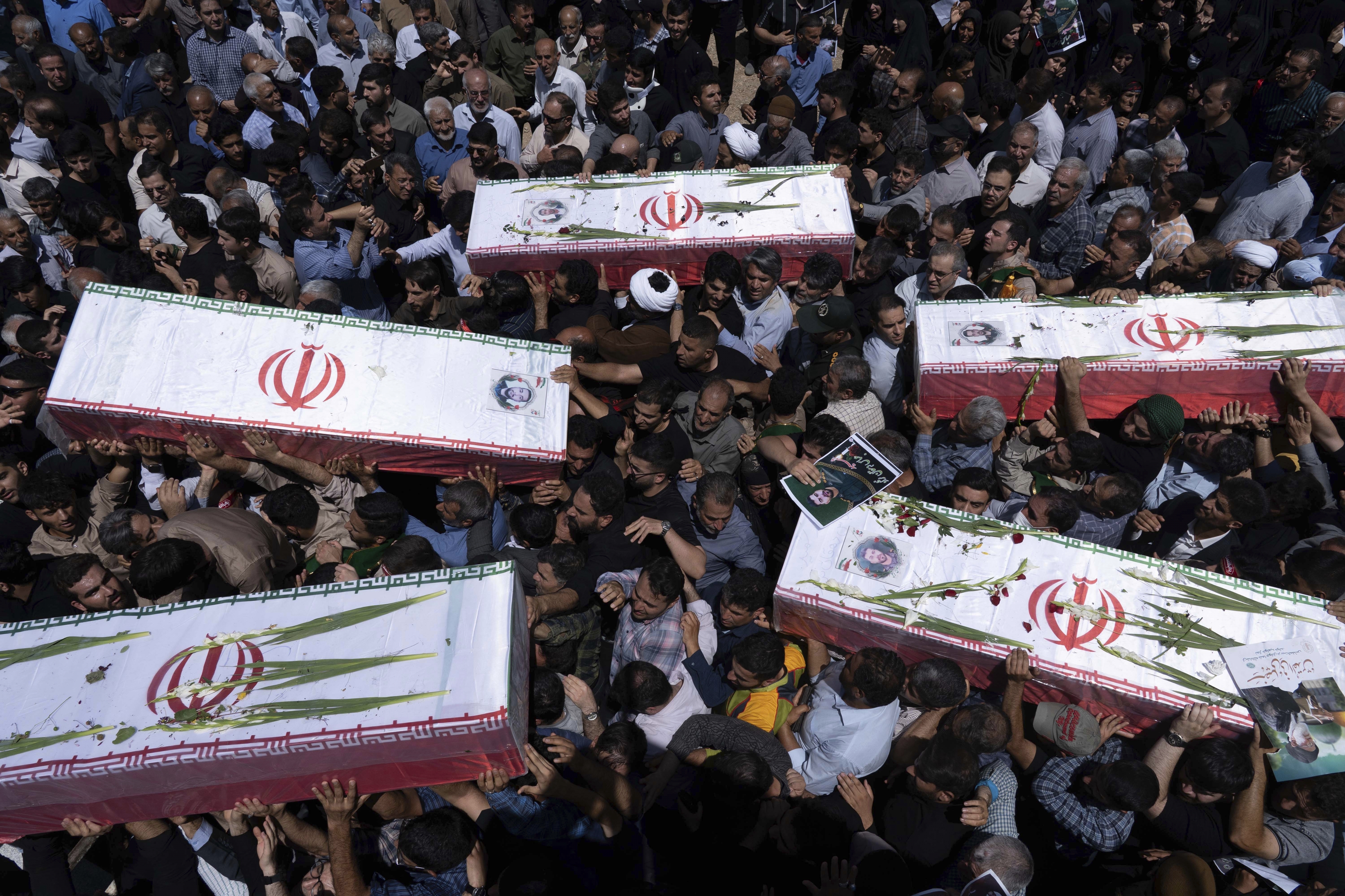 Mourners carry the flag-draped coffins of five men, whose names were not immediately available, reportedly killed in Israeli strikes, during their funeral in the city of Khorramabad, Iran, Monday, June 16, 2025. (AP Photo/Aziz Babanezhad/Tasnim News Agency)
