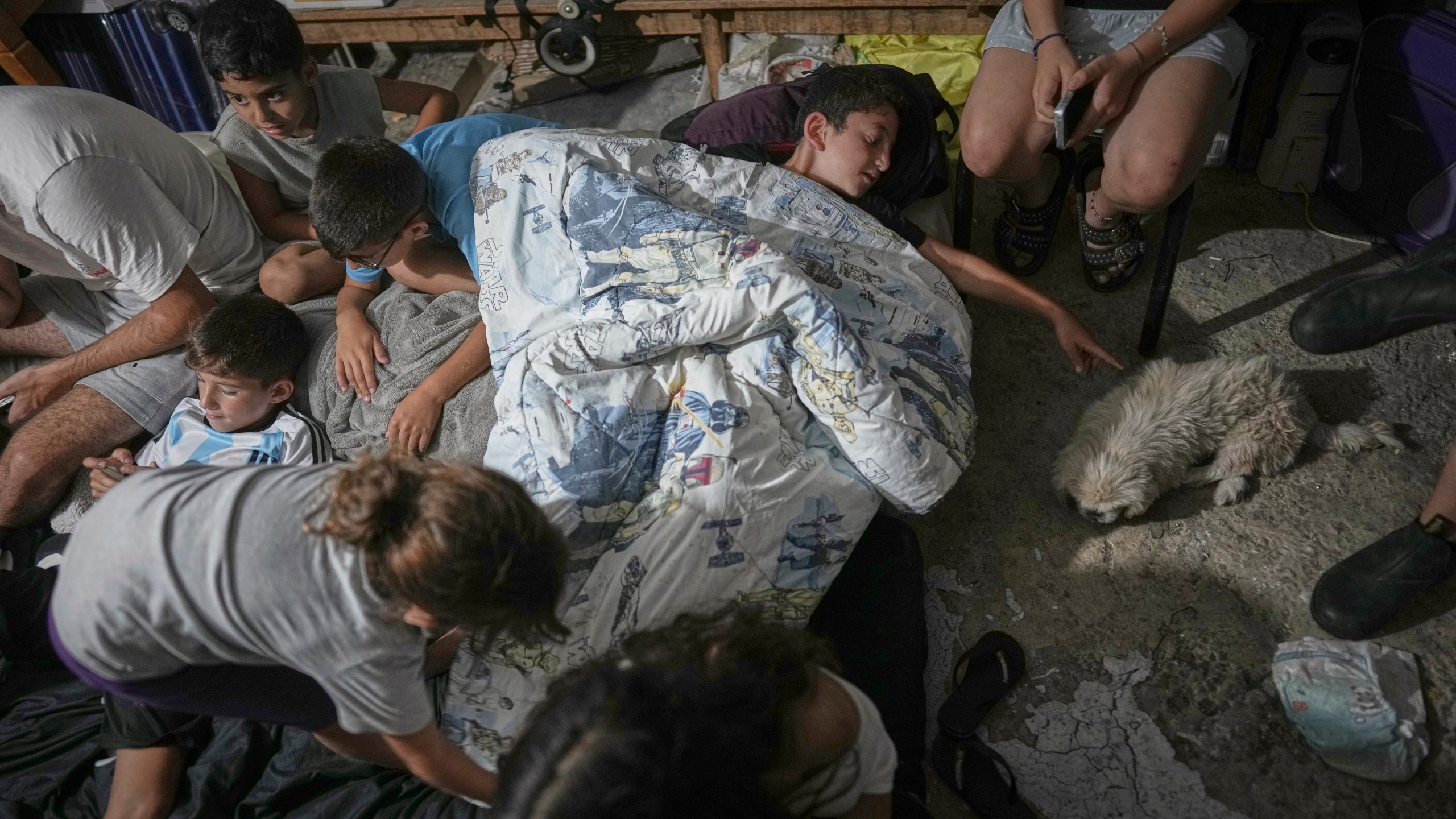 Israeli children take shelter during air raid sirens warning of incoming strikes by Iran, in Bnei Brak, near Tel Aviv, Israel, Tuesday, June 17, 2025. (AP Photo/Oded Balilty)