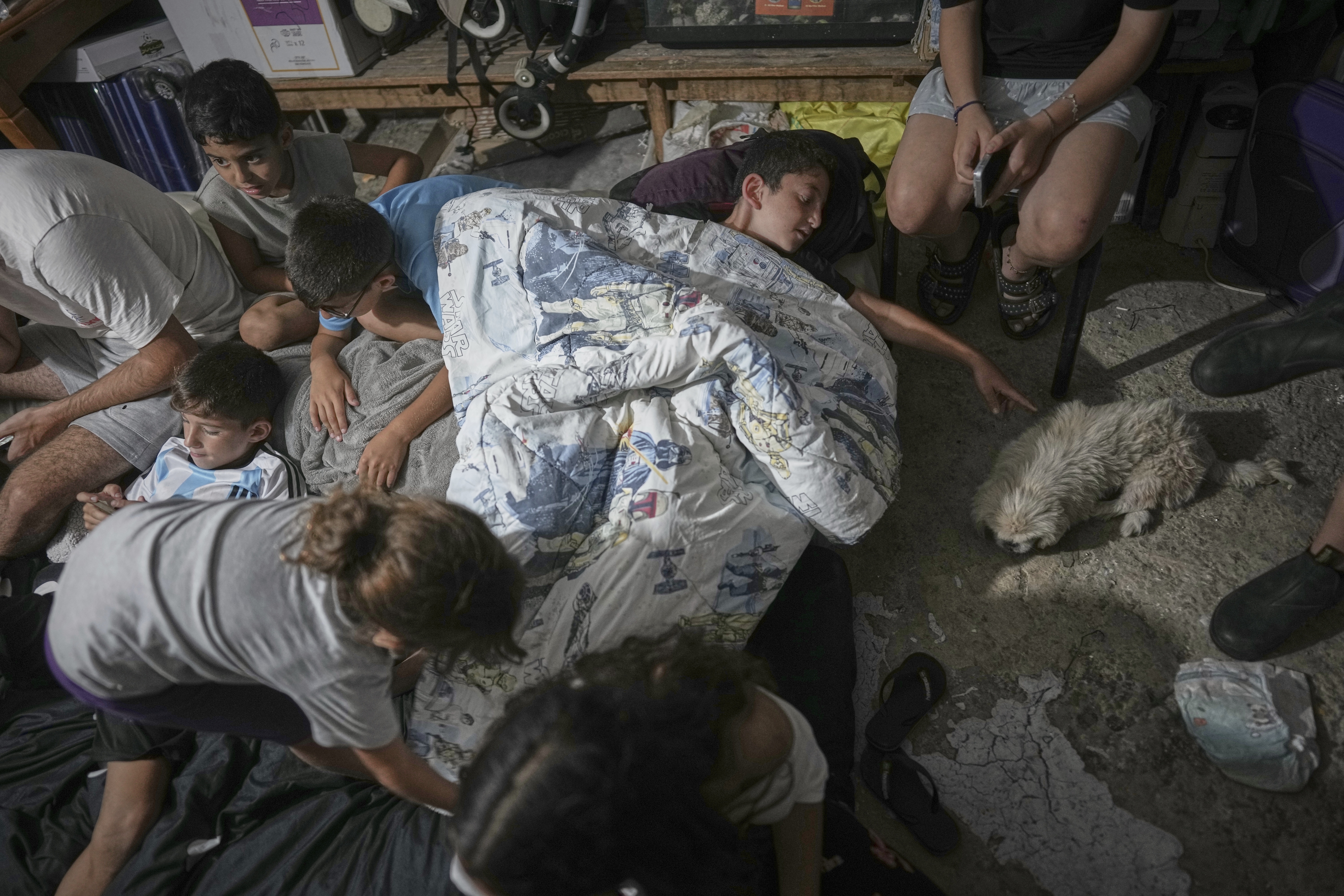 Israeli children take shelter during air raid sirens warning of incoming strikes by Iran, in Bnei Brak, near Tel Aviv, Israel, Tuesday, June 17, 2025. (AP Photo/Oded Balilty)