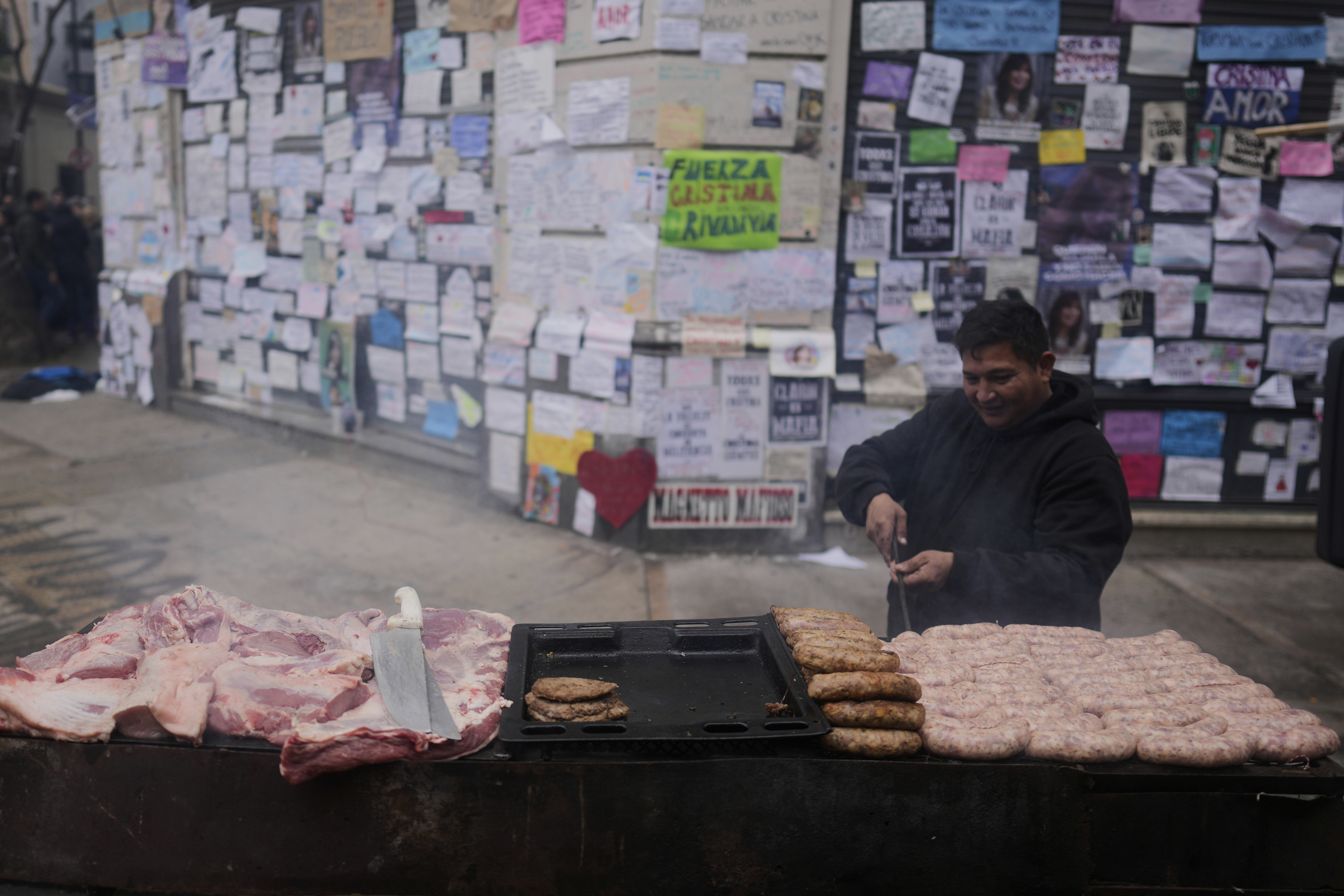A street vendor cooks barbecue outside the home of Argentina's former President Cristina Fernandez after the nation's Supreme Court upheld her corruption conviction in Buenos Aires, Argentina, Tuesday, June 17, 2025. (AP Photo/Natacha Pisarenko)