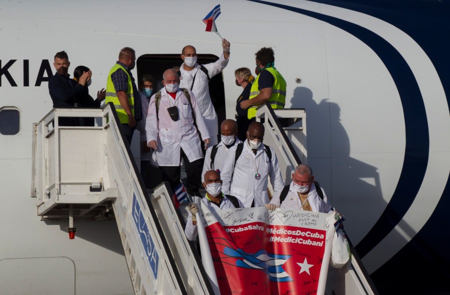 FILE - Cuban doctors arrive at the Jose Marti International Airport in Havana, Cuba, June 8, 2020, after traveling to Italy to help with the COVID-19 emergency response. (Ismael Francisco/Pool via AP, File)