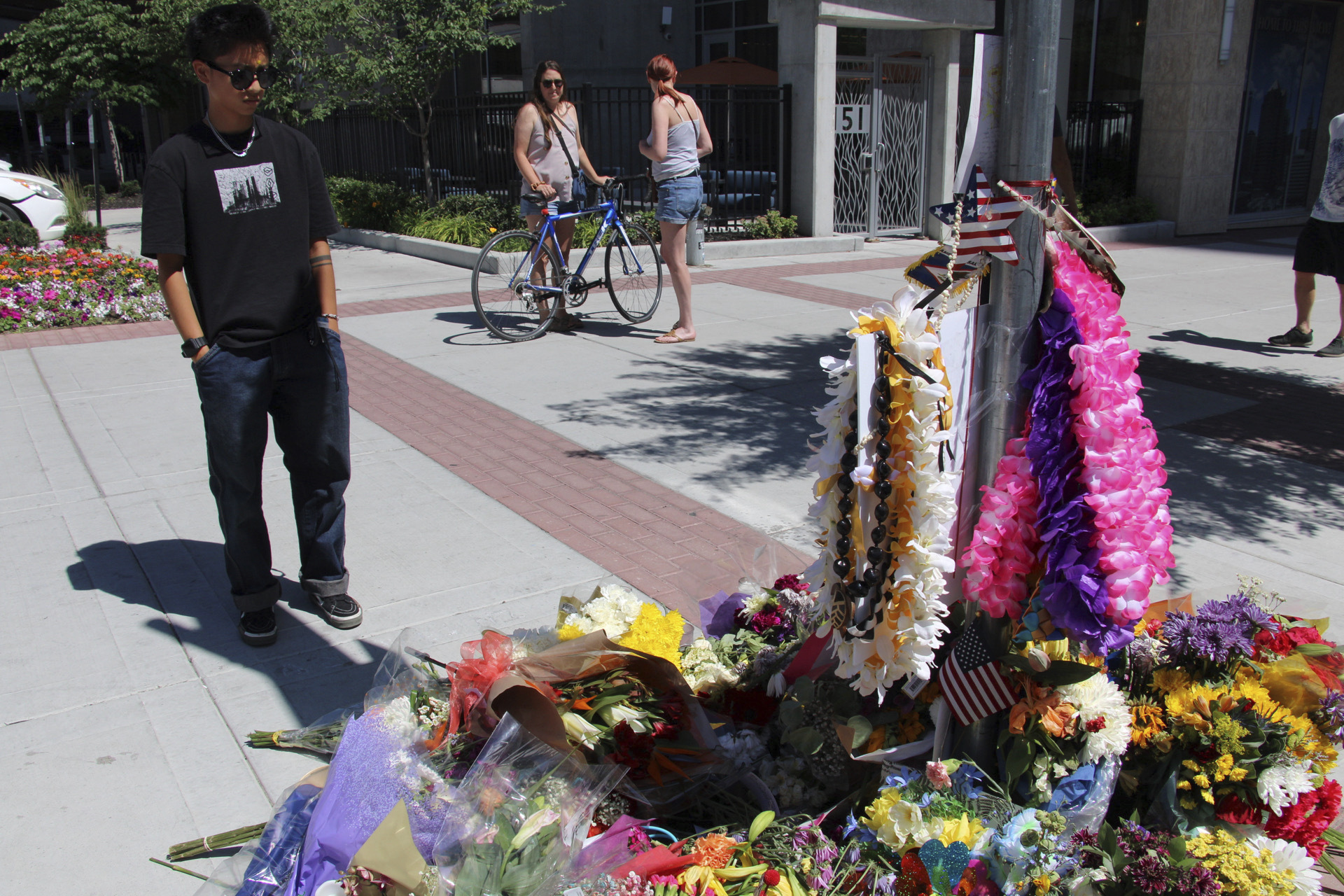 A young man pays his respects to Arthur Folasa Ah Loo, known to friends and family as Afa, Tuesday, June 17, 2025, at a makeshift memorial in Salt Lake City, on the block where Ah Loo was fatally shot during a "No Kings" protest on Saturday, June 14. (AP Photo/Hannah Schoenbaum)