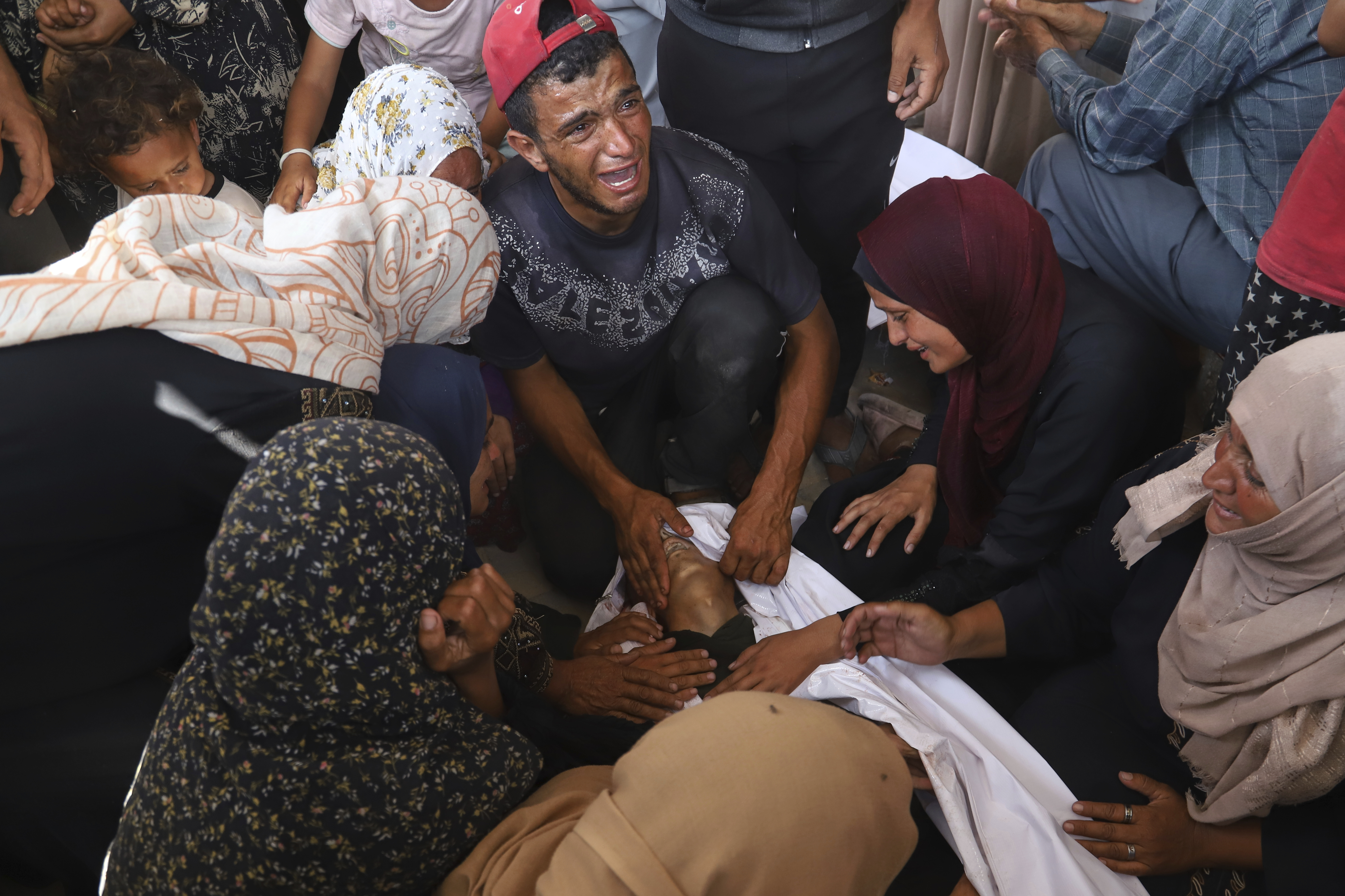 Palestinian relatives mourn over the body of a man killed in an Israeli strike, at Nasser Hospital in Khan Younis, southern Gaza Strip, Tuesday, June 17, 2025. (AP Photo/Mariam Dagga)