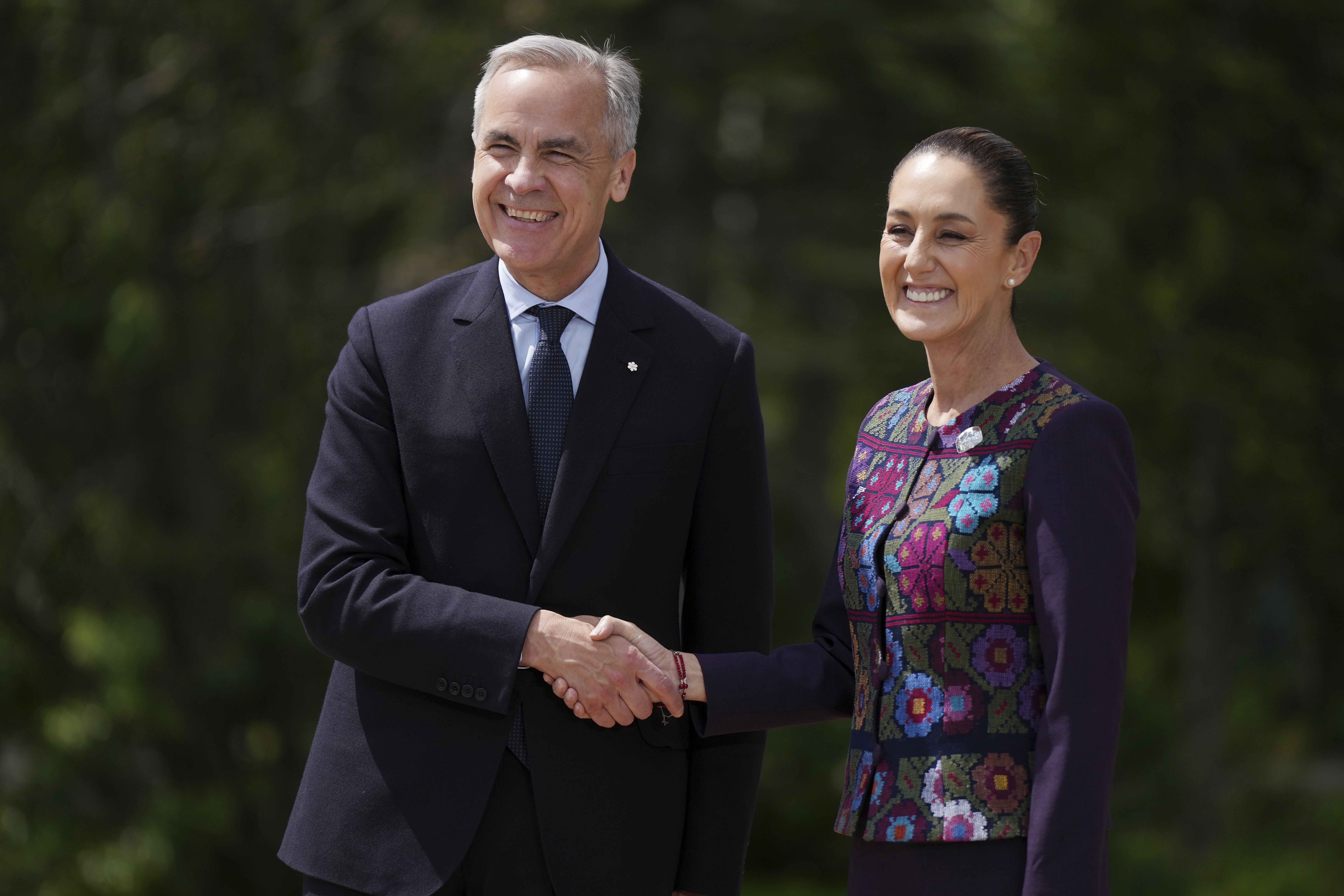 Canada's Prime Minister Mark Carney welcomes Mexican President Claudia Sheinbaum to the G7 Summit in Kananaskis, Alberta, Tuesday, June 17, 2025. (Darryl Dyck/The Canadian Press via AP)
