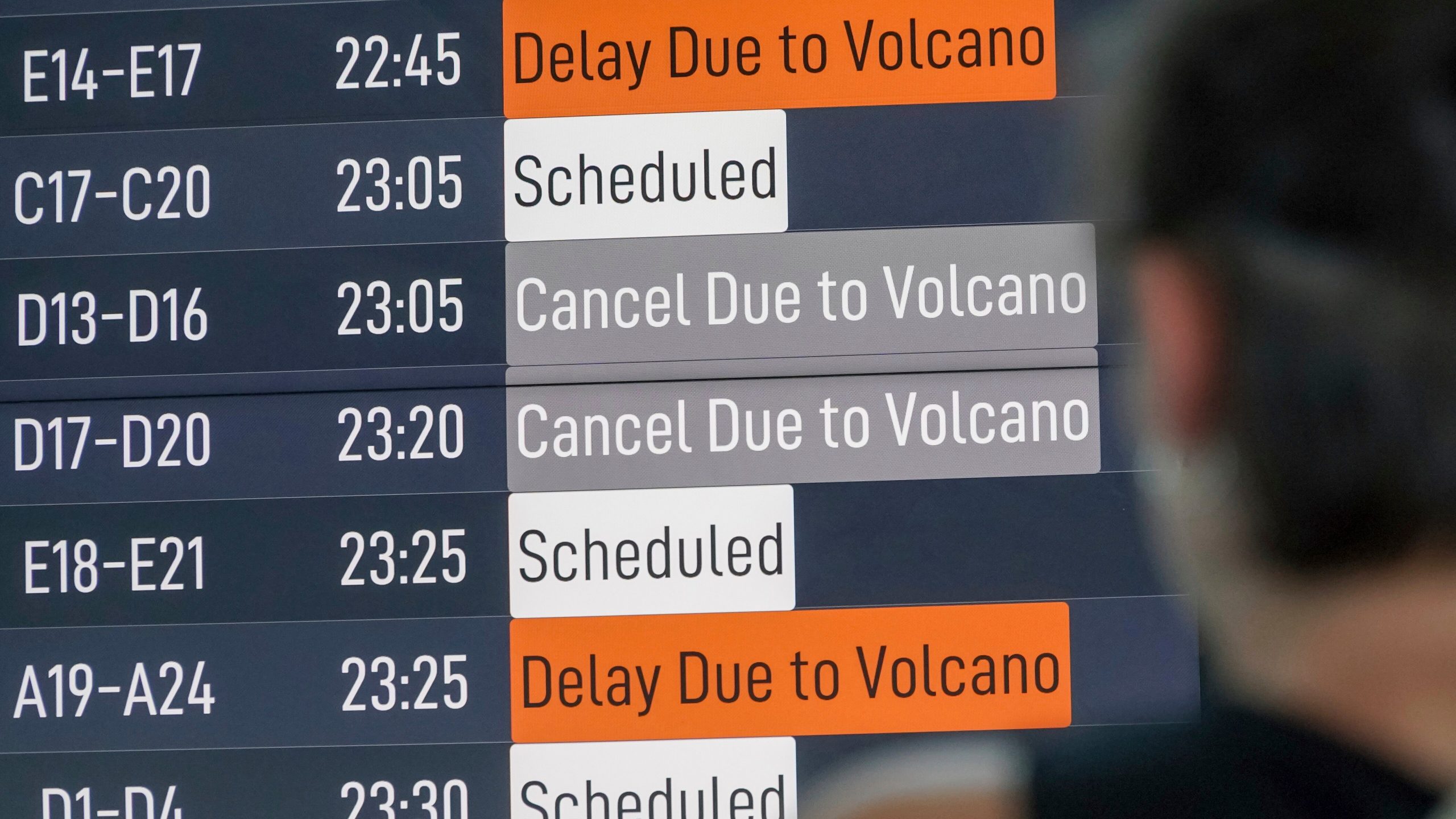 A passenger checks an information board showing disrupted flight schedule due to the eruption of Mount Lewotobi Laki-Laki, at Ngurah Rai International Airport in Badung, Bali, Indonesia, Wednesday, June 18, 2025. (AP Photo/Herdyanto)