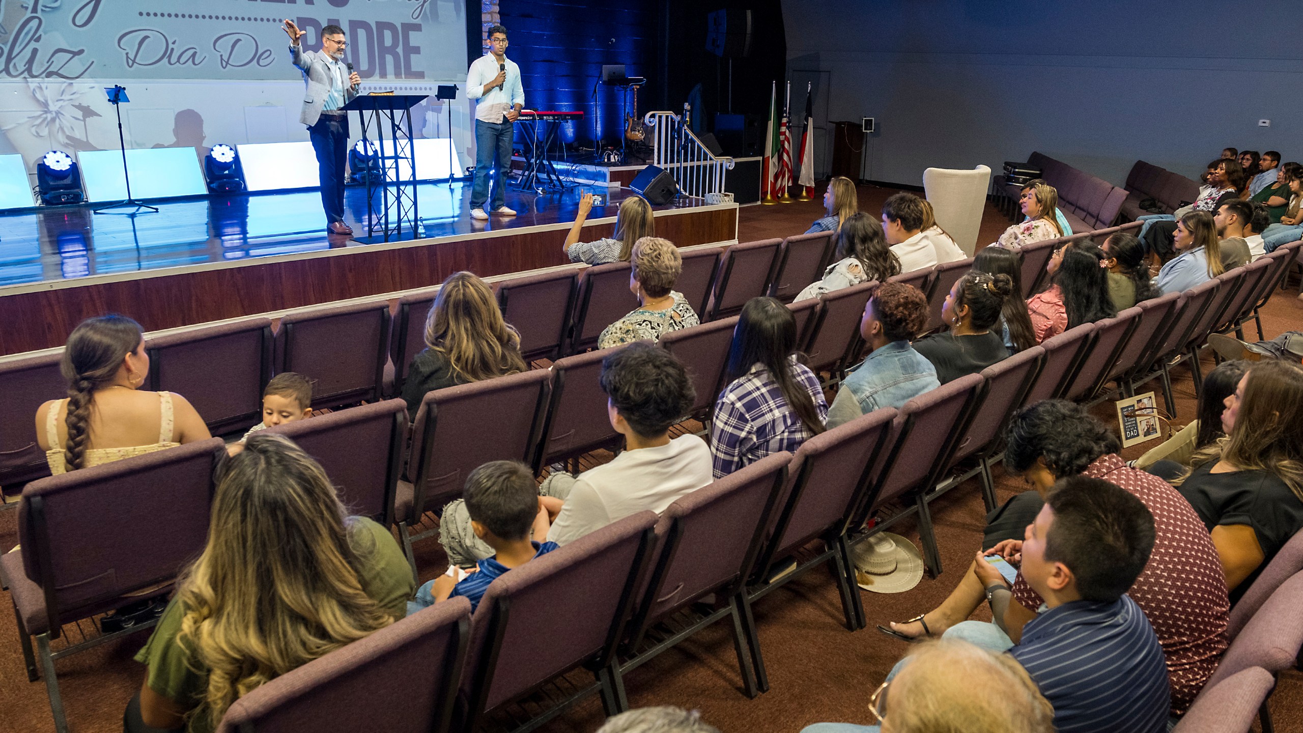 José Luis Orozco, a pastor from Nicaragua, left, flanked by his son, Josias, 17, translating, ministers to members of the Oasis Church, in Taylor, Texas, June 15, 2025. (AP Photo/Rodolfo Gonzalez)