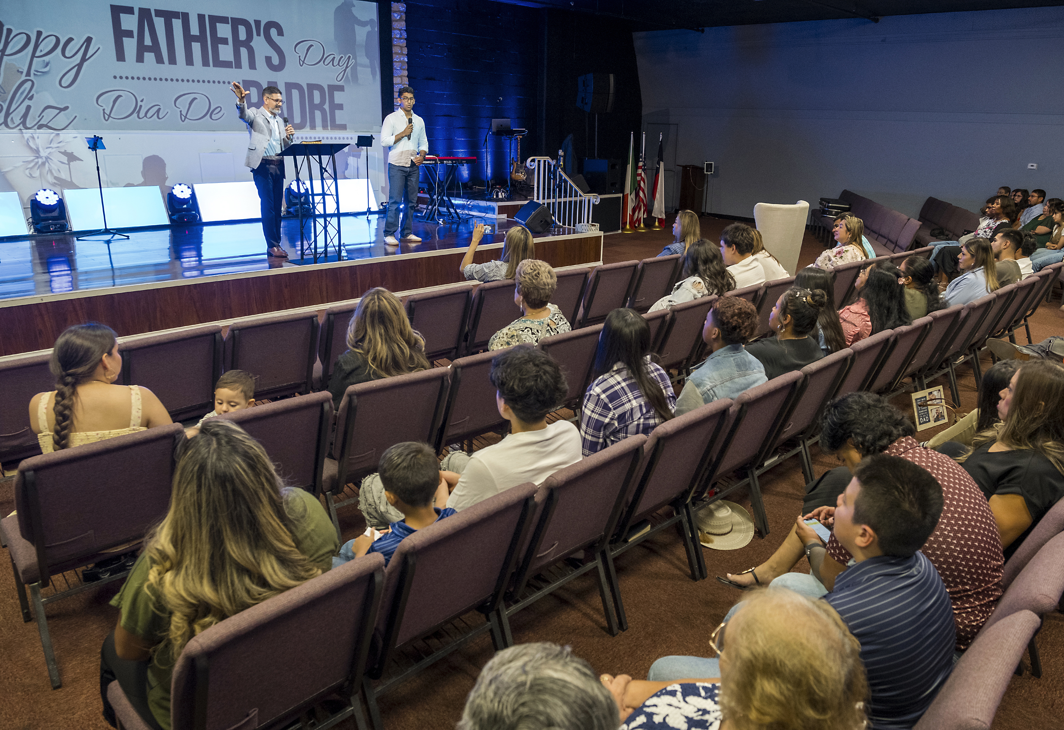 José Luis Orozco, a pastor from Nicaragua, left, flanked by his son, Josias, 17, translating, ministers to members of the Oasis Church, in Taylor, Texas, June 15, 2025. (AP Photo/Rodolfo Gonzalez)