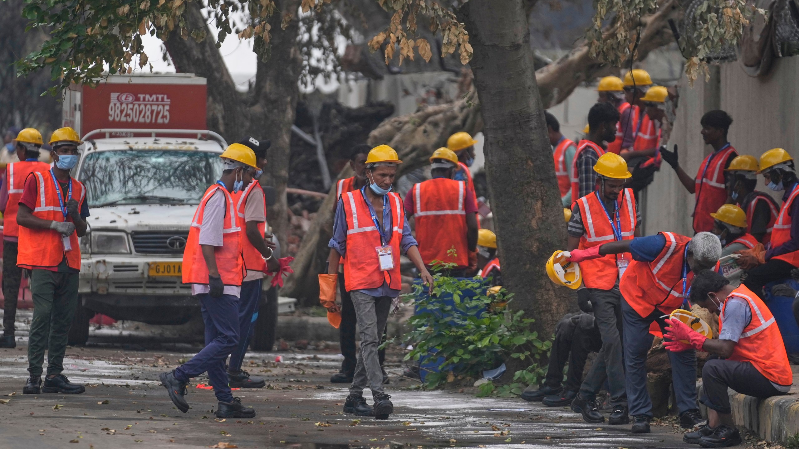 Local workers take a break near the site of the deadly Air India plane crash in Ahmedabad, India, Monday, June 16, 2025. (AP Photo/Rafiq Maqbool)