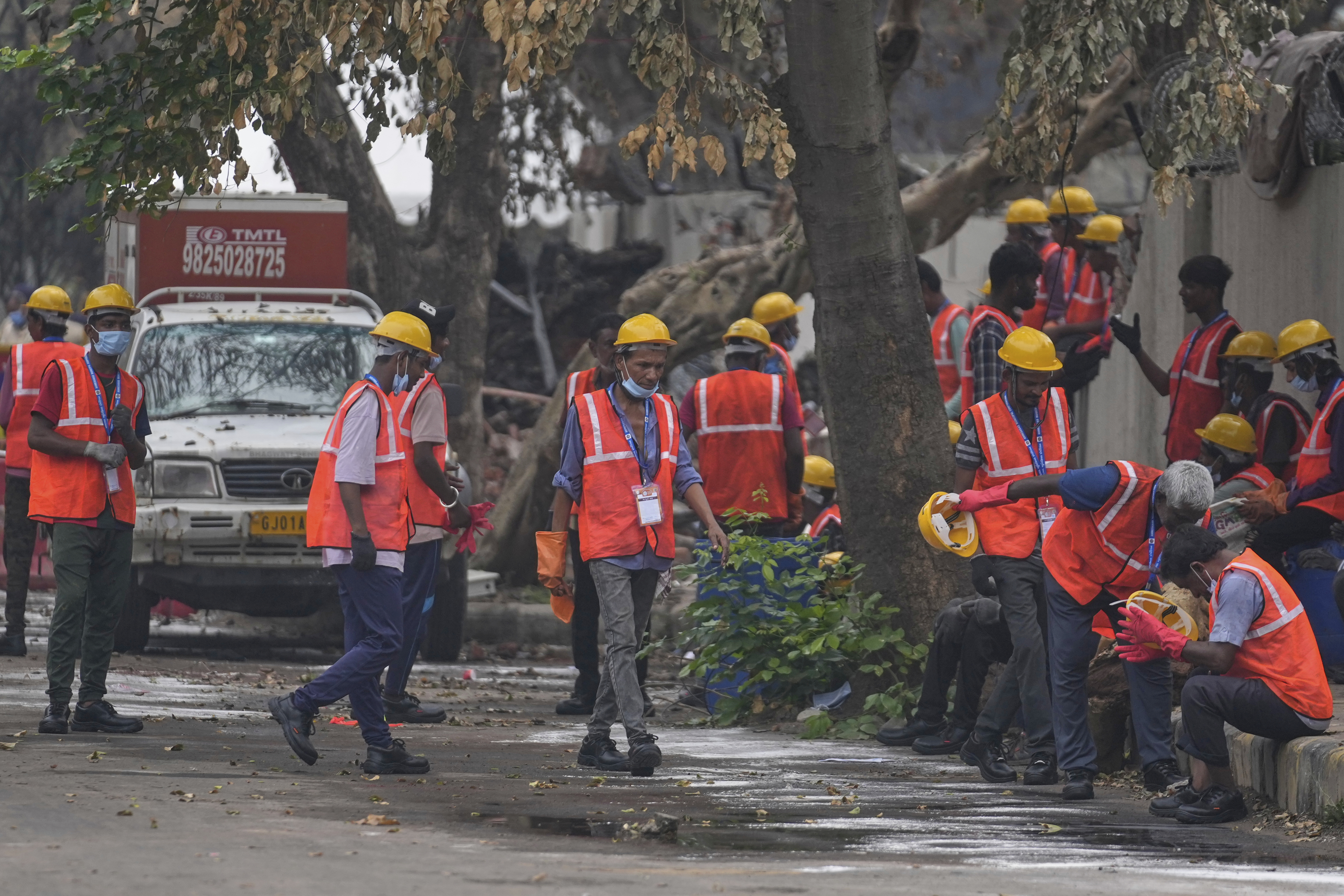 Local workers take a break near the site of the deadly Air India plane crash in Ahmedabad, India, Monday, June 16, 2025. (AP Photo/Rafiq Maqbool)