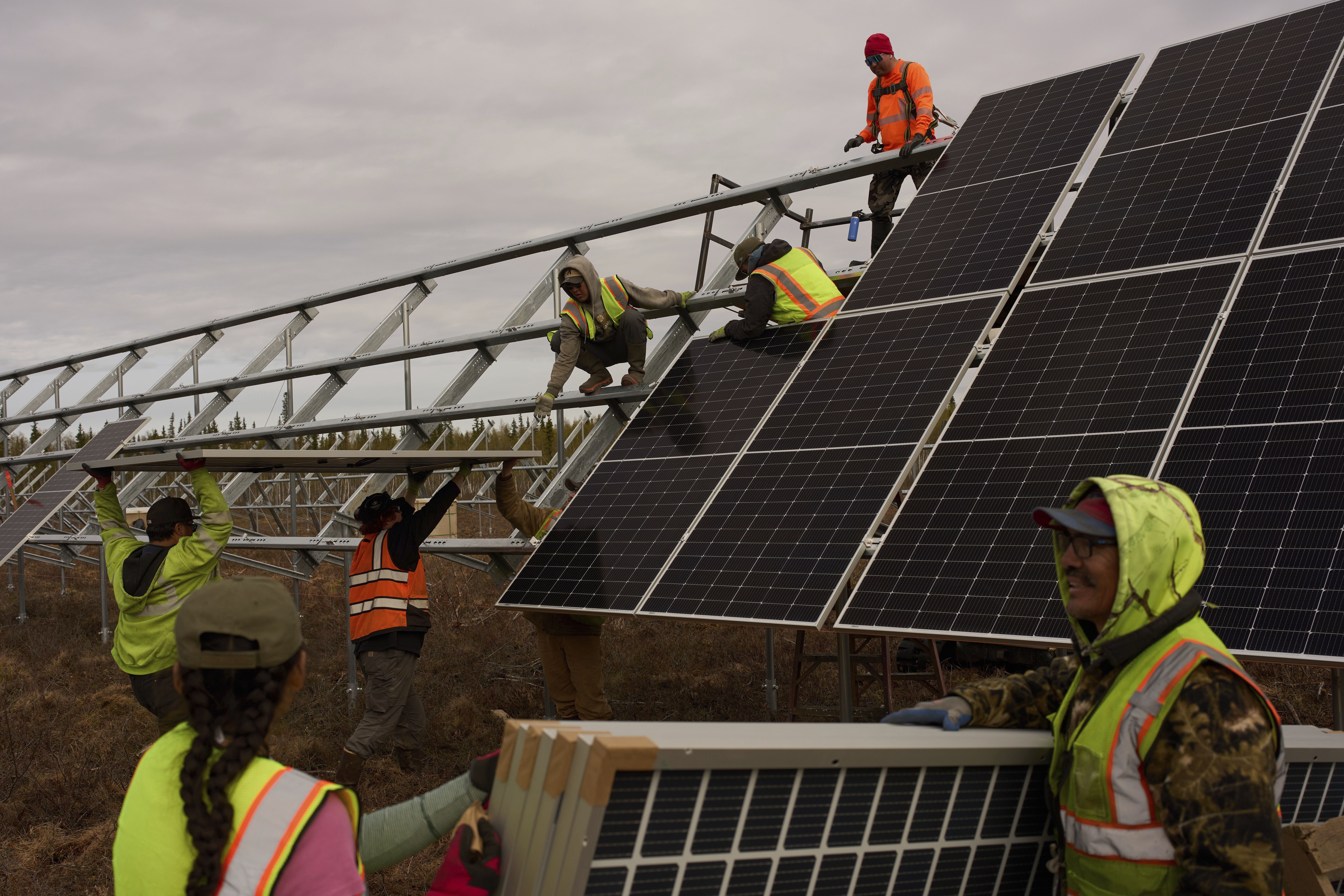 Workers install panels at a solar project Wednesday, May 21, 2025, in Galena, Alaska. (AP Photo/John Locher)
