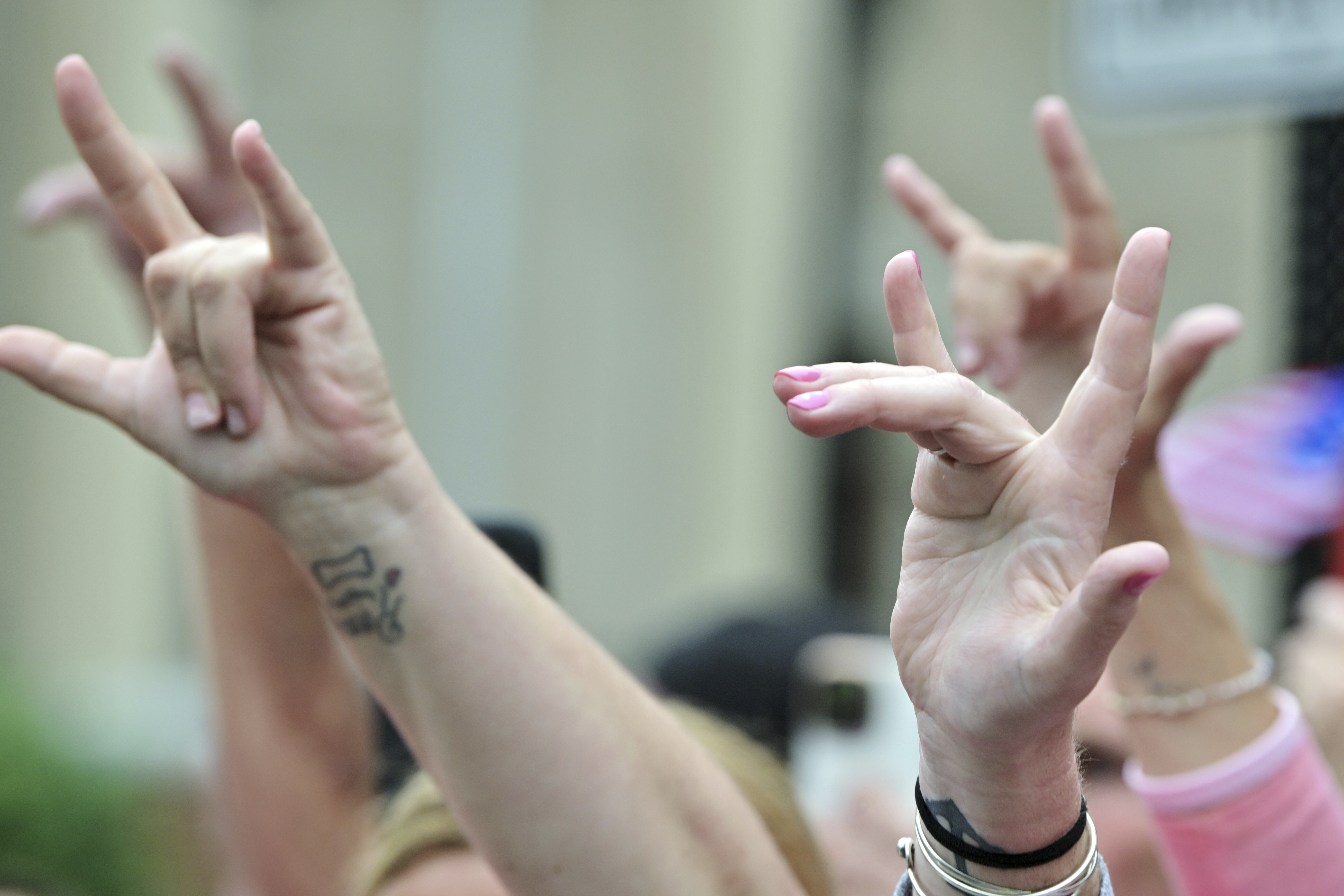 Supporters of Karen Read make the American Sign Language sign for "I Love You" as she leaves the courthouse at the start of the third day of jury deliberations in Read's trial at Norfolk Superior Court, Wednesday, June 18, 2025, in Dedham, Mass. (AP Photo/Josh Reynolds)