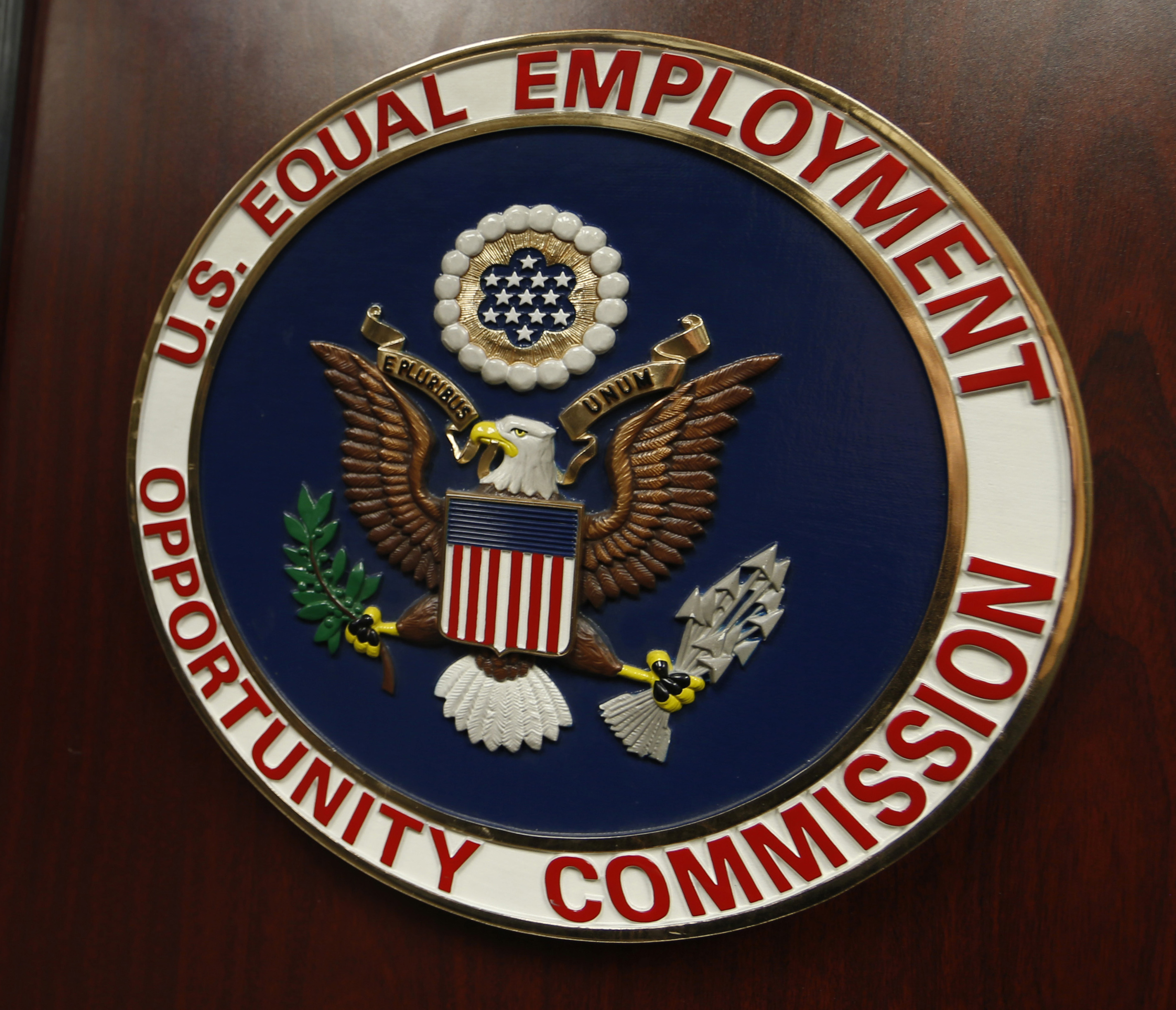 FILE - The emblem of the U.S. Equal Employment Opportunity Commission (EEOC) is shown on a podium in Vail, Colo., Feb. 16, 2016. (AP Photo/David Zalubowski, File)