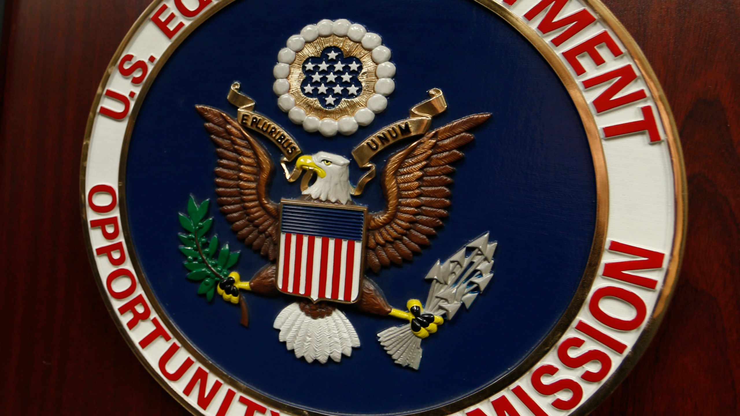 FILE - The emblem of the U.S. Equal Employment Opportunity Commission (EEOC) is shown on a podium in Vail, Colo., Feb. 16, 2016. (AP Photo/David Zalubowski, File)