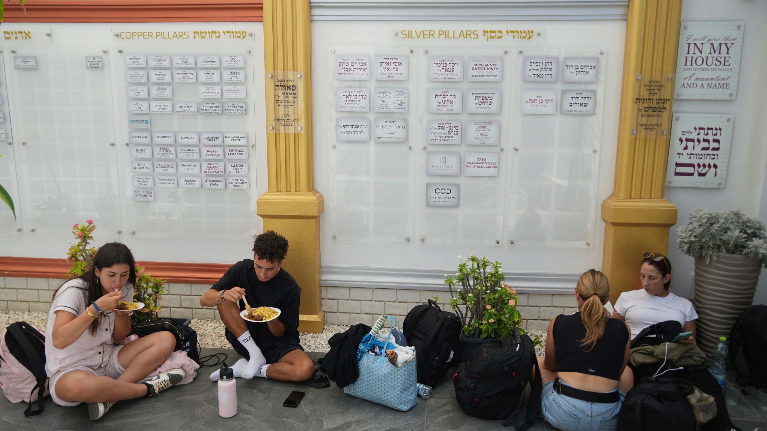 Evacuees from Israel eat food at a Jews community center after they arrived from Israel with a ship, at the port of Larnaca, Cyprus, Wednesday, June 18, 2025. (AP Photo/Petros Karadjias)