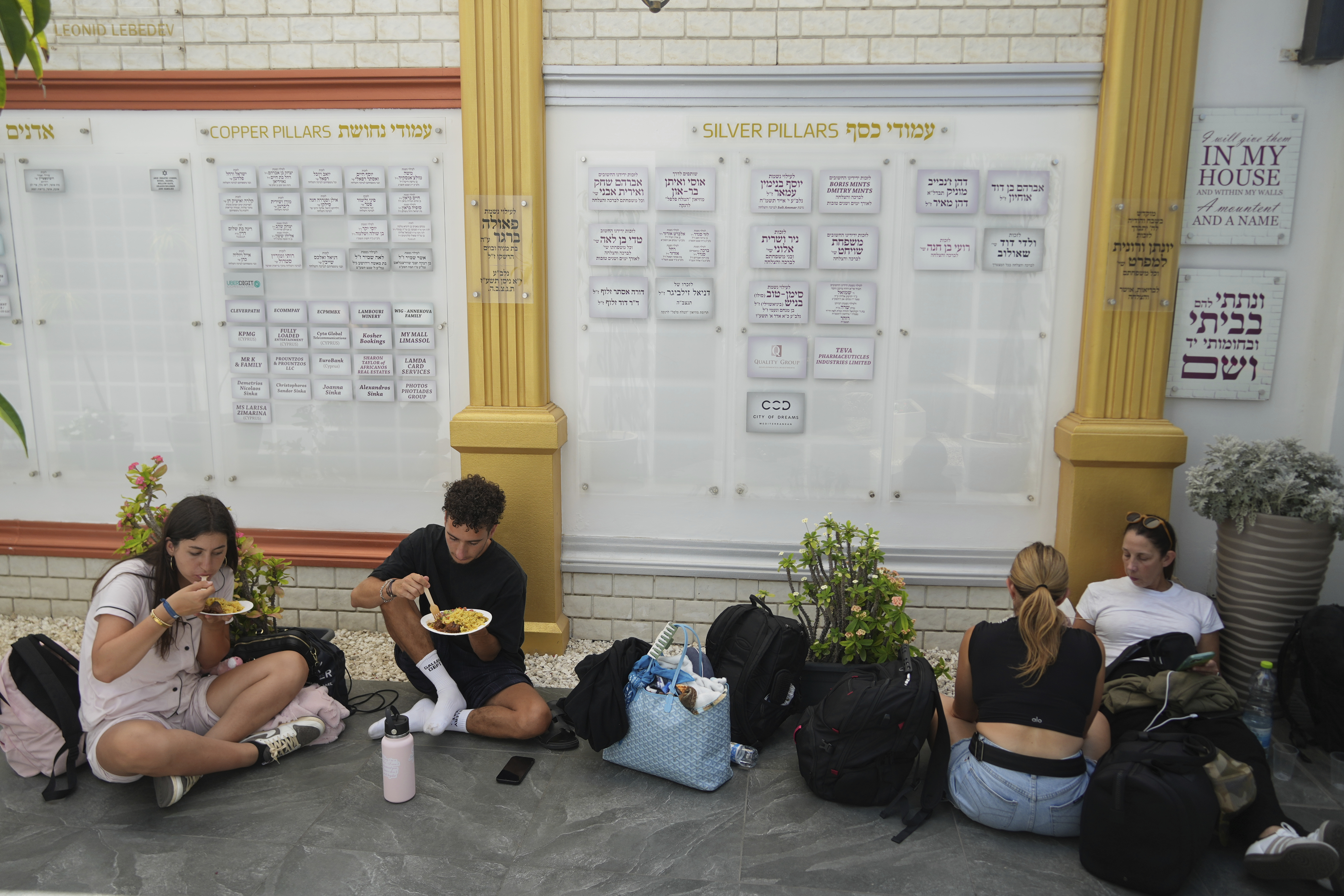 Evacuees from Israel eat food at a Jews community center after they arrived from Israel with a ship, at the port of Larnaca, Cyprus, Wednesday, June 18, 2025. (AP Photo/Petros Karadjias)