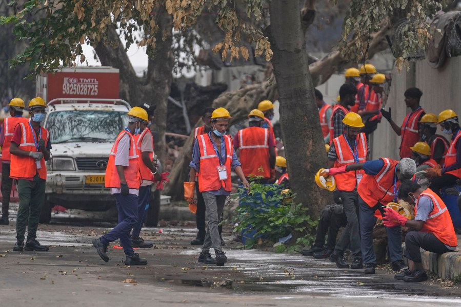 Local workers take a break near the site of the deadly Air India plane crash in Ahmedabad, India, Monday, June 16, 2025. (AP Photo/Rafiq Maqbool)