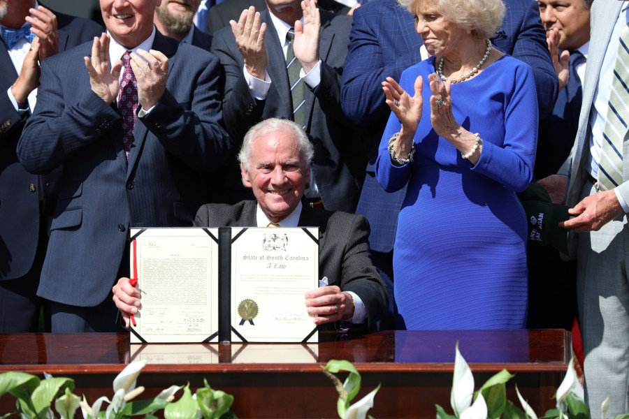 Republican South Carolina Gov. Henry McMaster holds up a ceremonial copy of a bill he signed changing South Carolina's energy laws on Wednesday, June 18, 2025, in Columbia, S.C. (AP Photo/Jeffrey Collins)