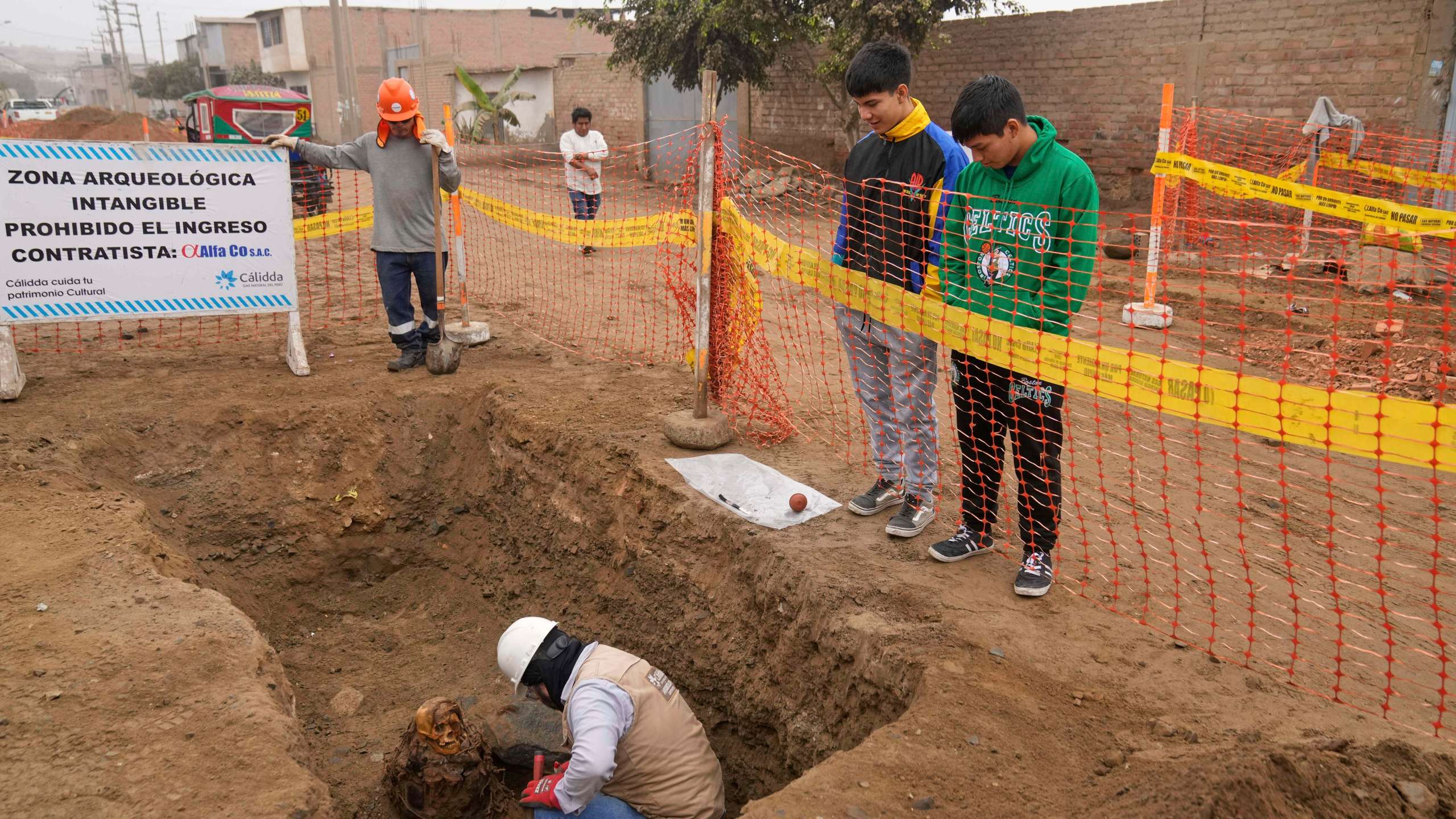 Archaeologist Jose Aliaga excavates an ancient mummy, which he said is a female from the pre-Inca Chancay culture, that was discovered by city workers who were digging a natural gas line for the company Calidda in the district of Puente Piedra on the outskirts of Lima, Peru, Wednesday, June 18, 2025. (AP Photo/Martin Mejia)