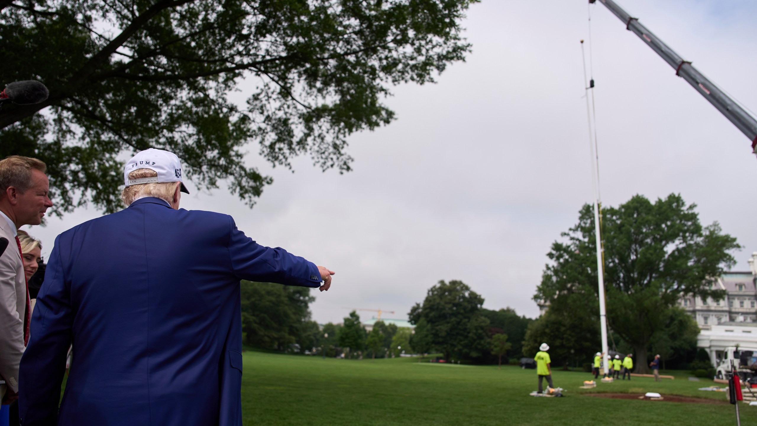 President Donald Trump speaks with reporters as a flag pole is installed on the South Lawn of the White House, Wednesday, June 18, 2025, in Washington. (AP Photo/Evan Vucci)