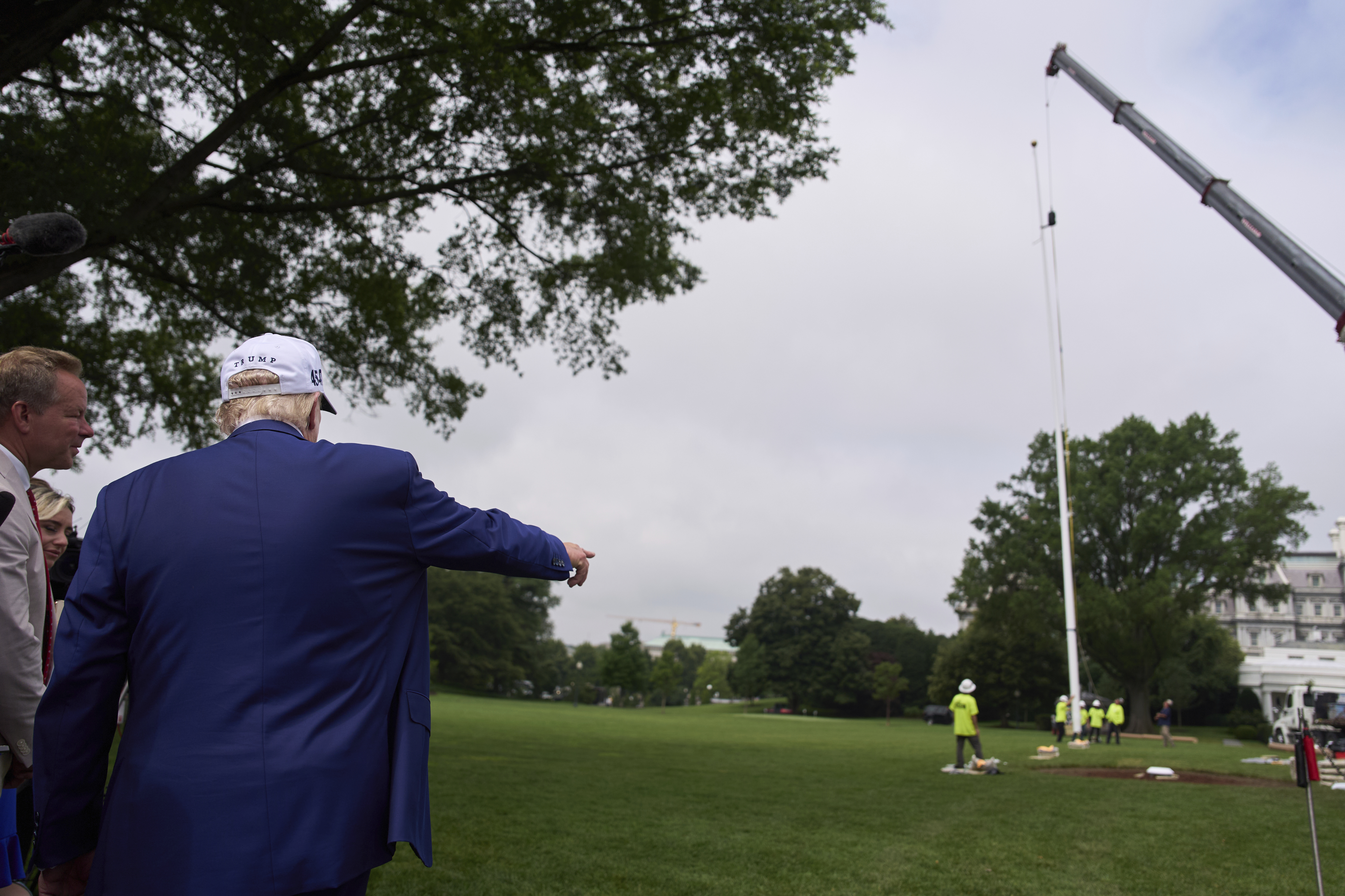 President Donald Trump speaks with reporters as a flag pole is installed on the South Lawn of the White House, Wednesday, June 18, 2025, in Washington. (AP Photo/Evan Vucci)