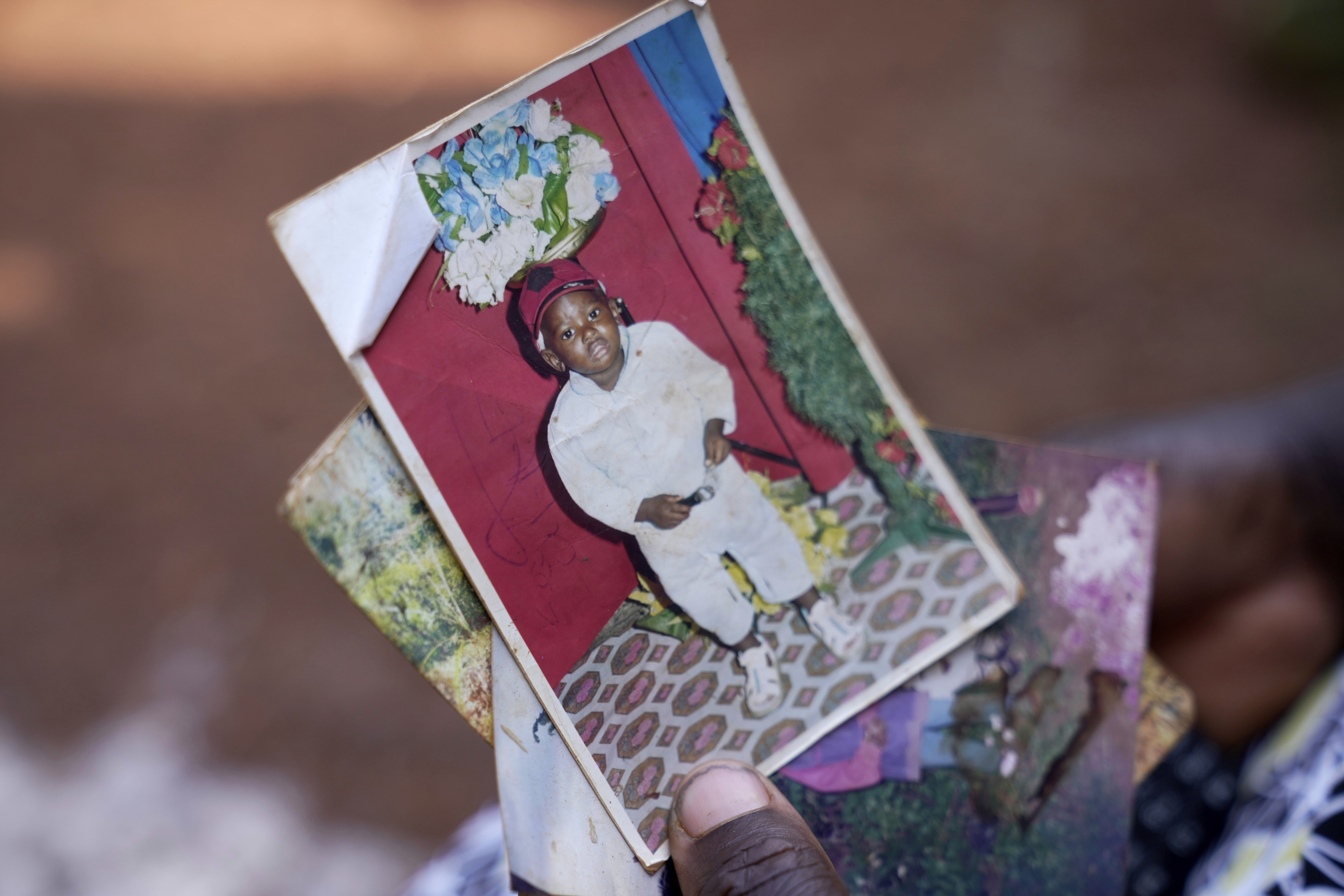 Susan Njeri, 44 years old, whose son Boniface Kariuki was shot at close range by a Kenyan police officer during a protest, holds his picture in Muranga, Kenya, Wednesday, June 18, 2025. (AP Photo/Brian Inganga)