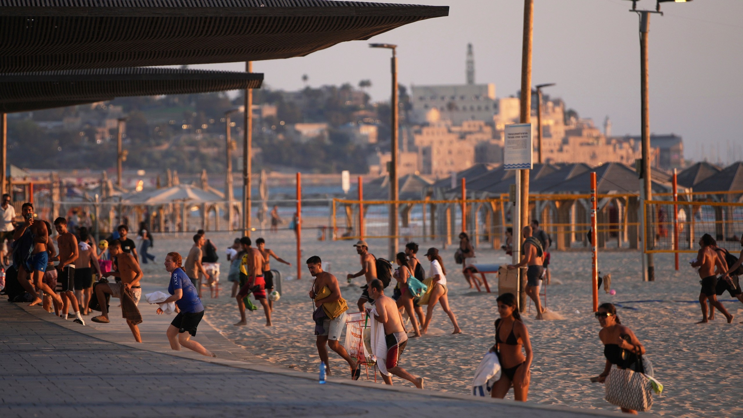 Beachgoers leave during a missile alert from Iran, in Tel Aviv, Israel, Wednesday, June 18, 2025. (AP Photo/Ohad Zwigenberg)